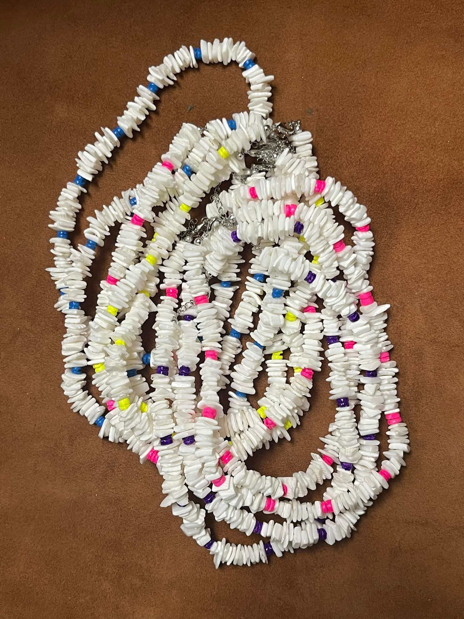 White shell lei with blue, yellow, pink, and purple accents in a USA shop.