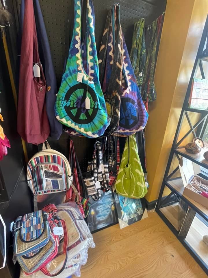 Bags of various sizes and patterns on display in a store; peace sign and floral motifs prominent.