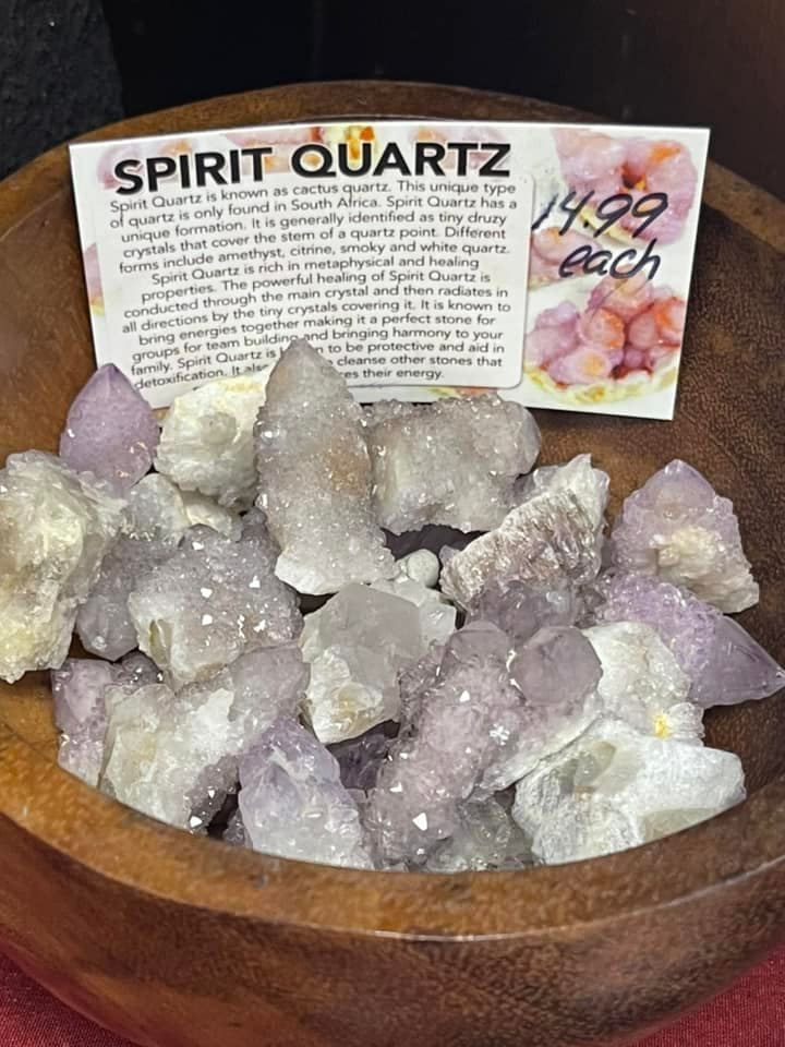 Bowl of Spirit Quartz crystals, mostly light purple and white, with a price tag.