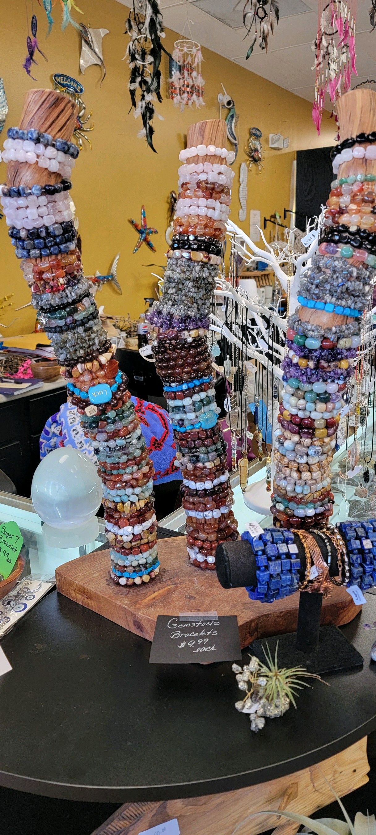 Bracelets displayed on wooden stands inside a USA crystal and jewelry shop.