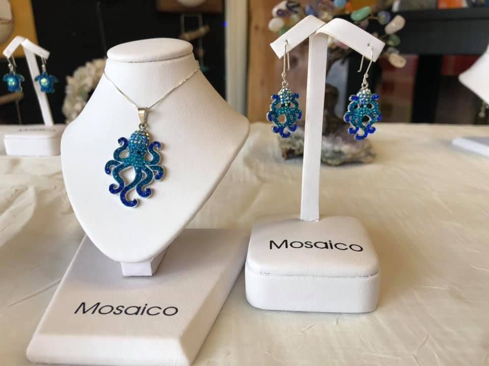 Blue octopus jewelry set on white display stands labeled 