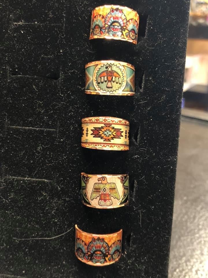 Five colorful Native American-style rings displayed in a black ring holder.
