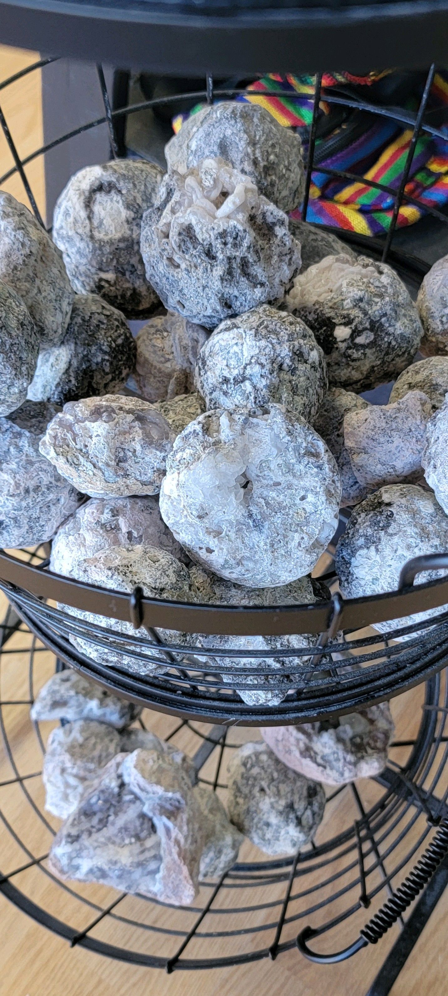 A wire basket filled with gray and white textured stones.