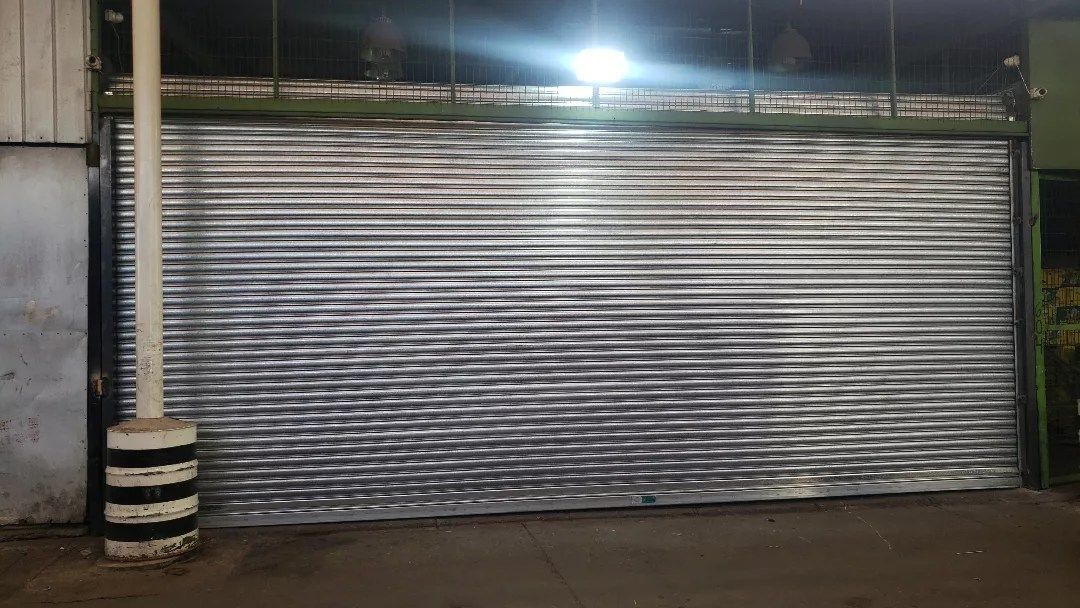 Un primer plano de una persiana metálica en un edificio por la noche.