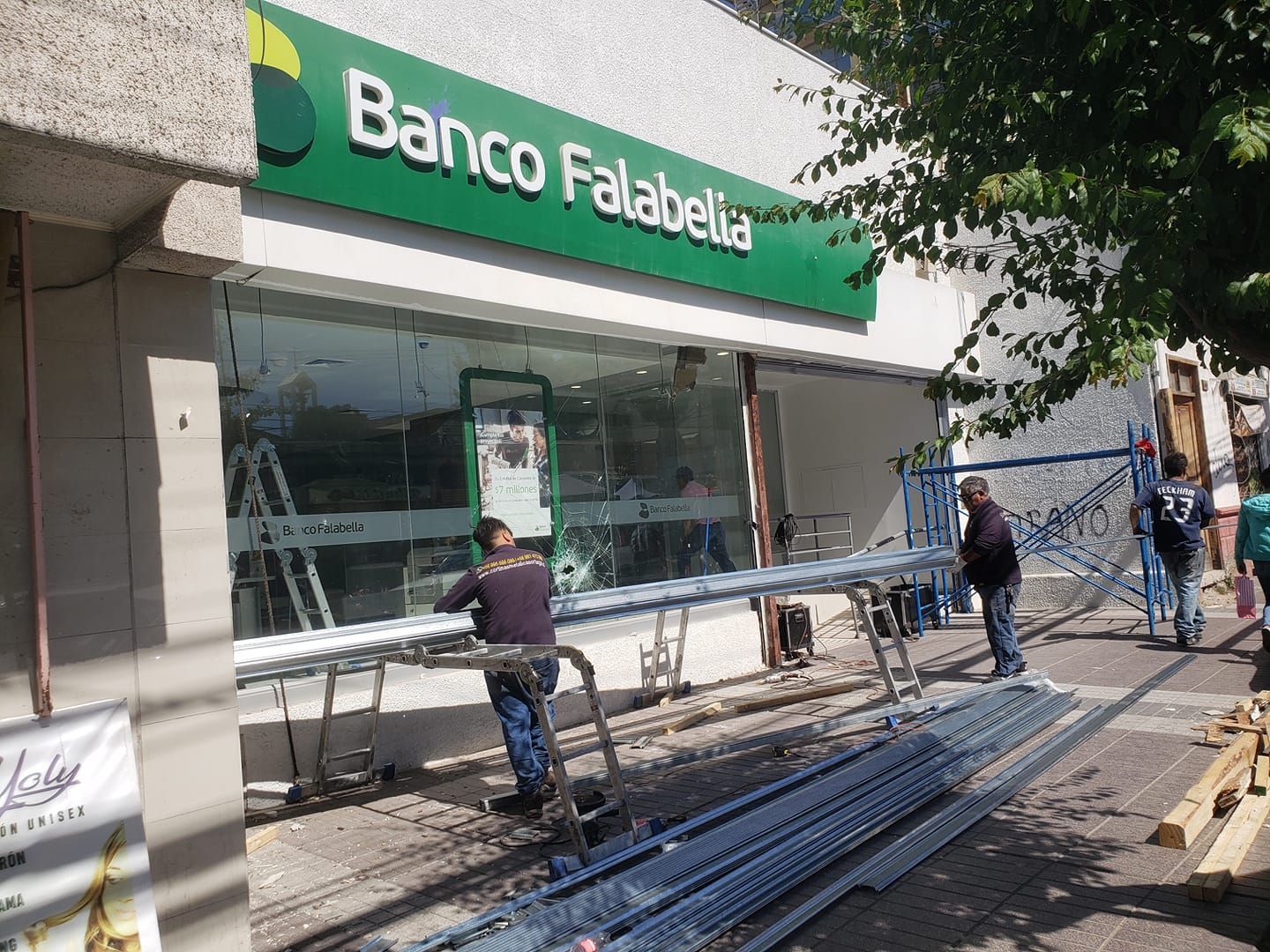 Un grupo de hombres trabaja afuera de un banco Falabella.