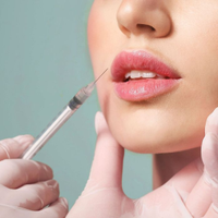 A syringe near a womanโs lips during a cosmetic injection procedure