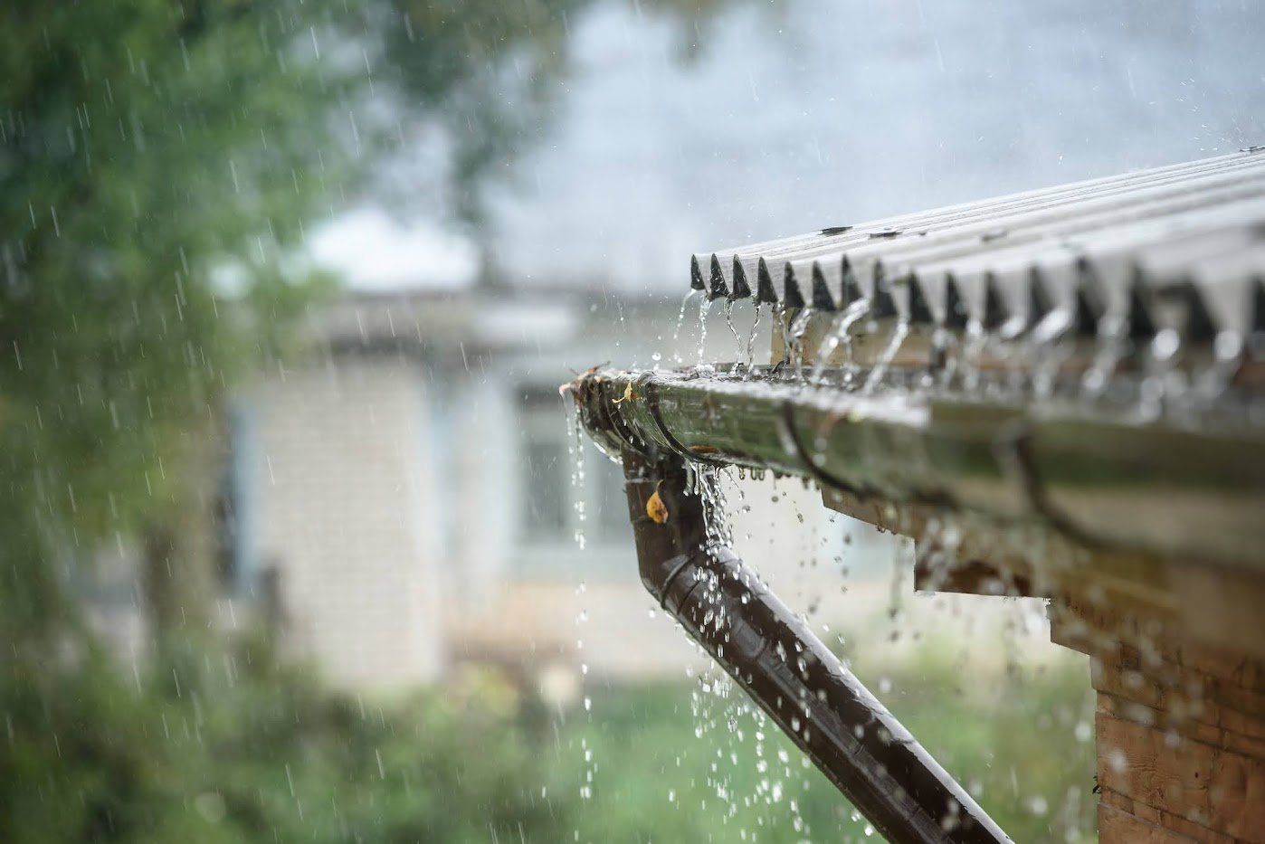 Rain is falling from the gutter of a house.