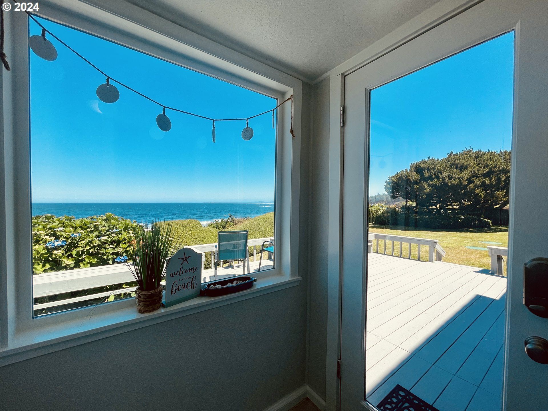 A window with a view of the ocean and a sign that says please