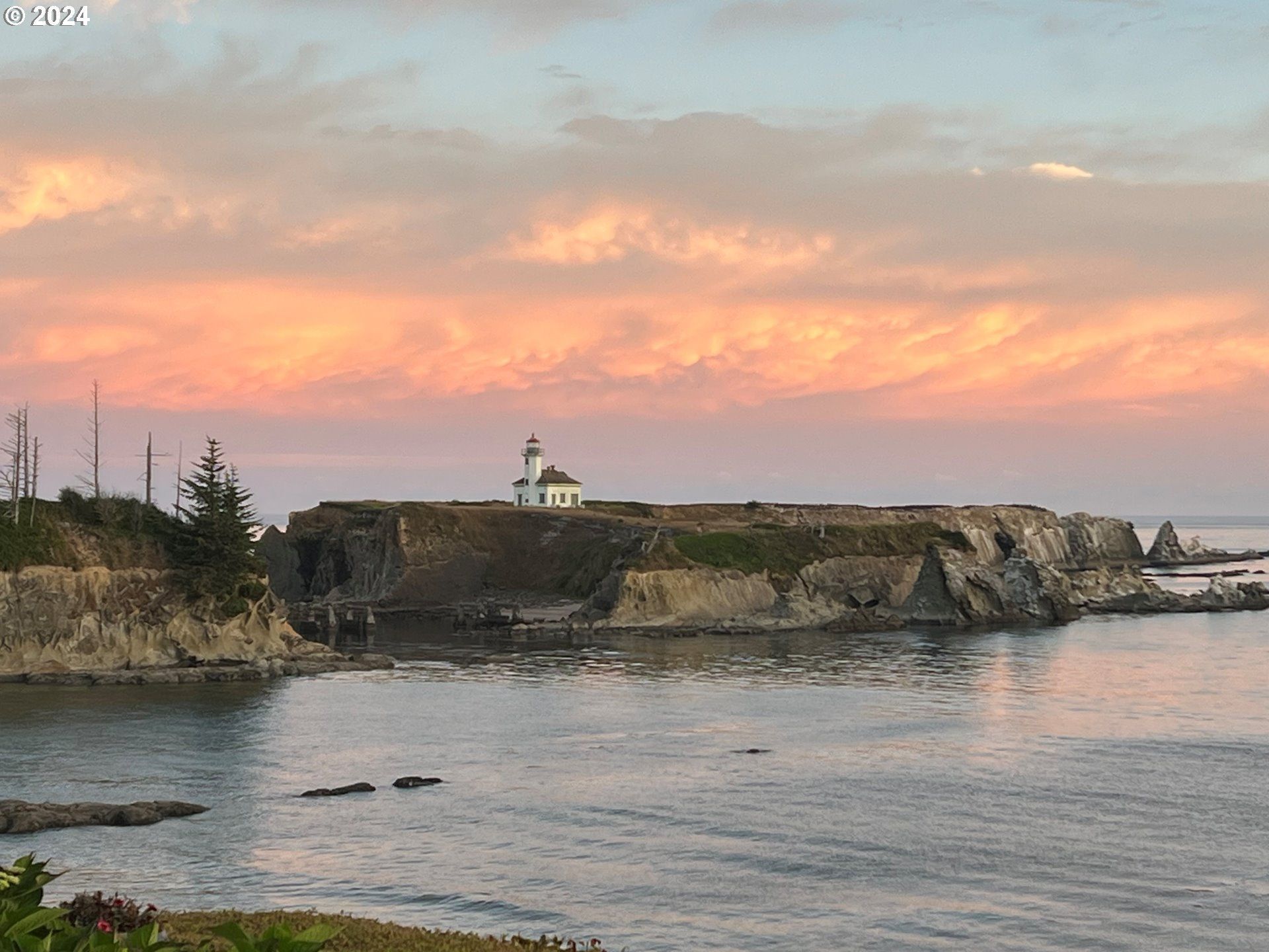A lighthouse on a cliff overlooking a body of water