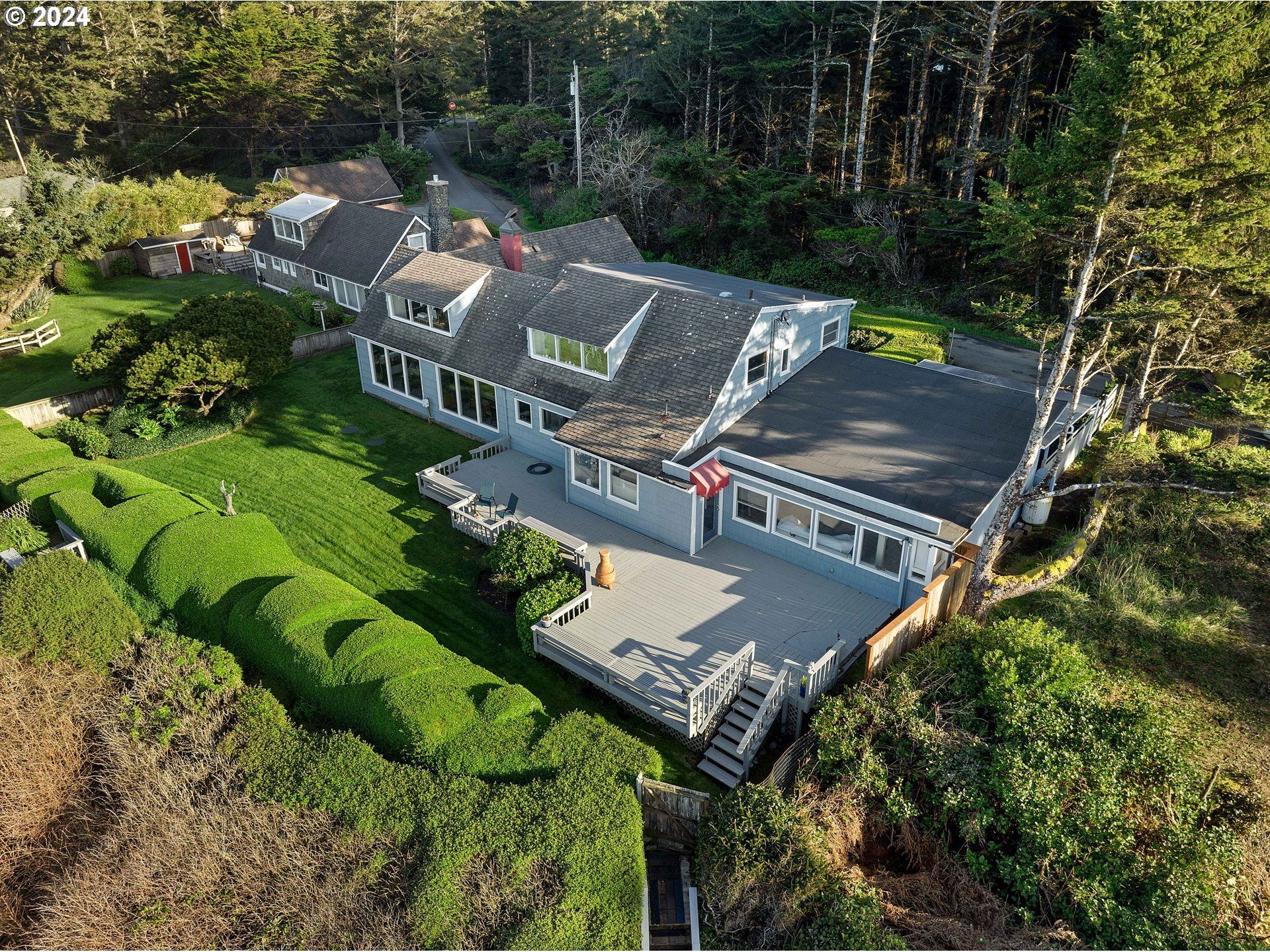 An aerial view of a large white house with a black roof