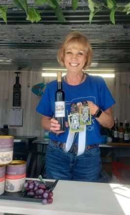 Women holding awards and a wine bottle