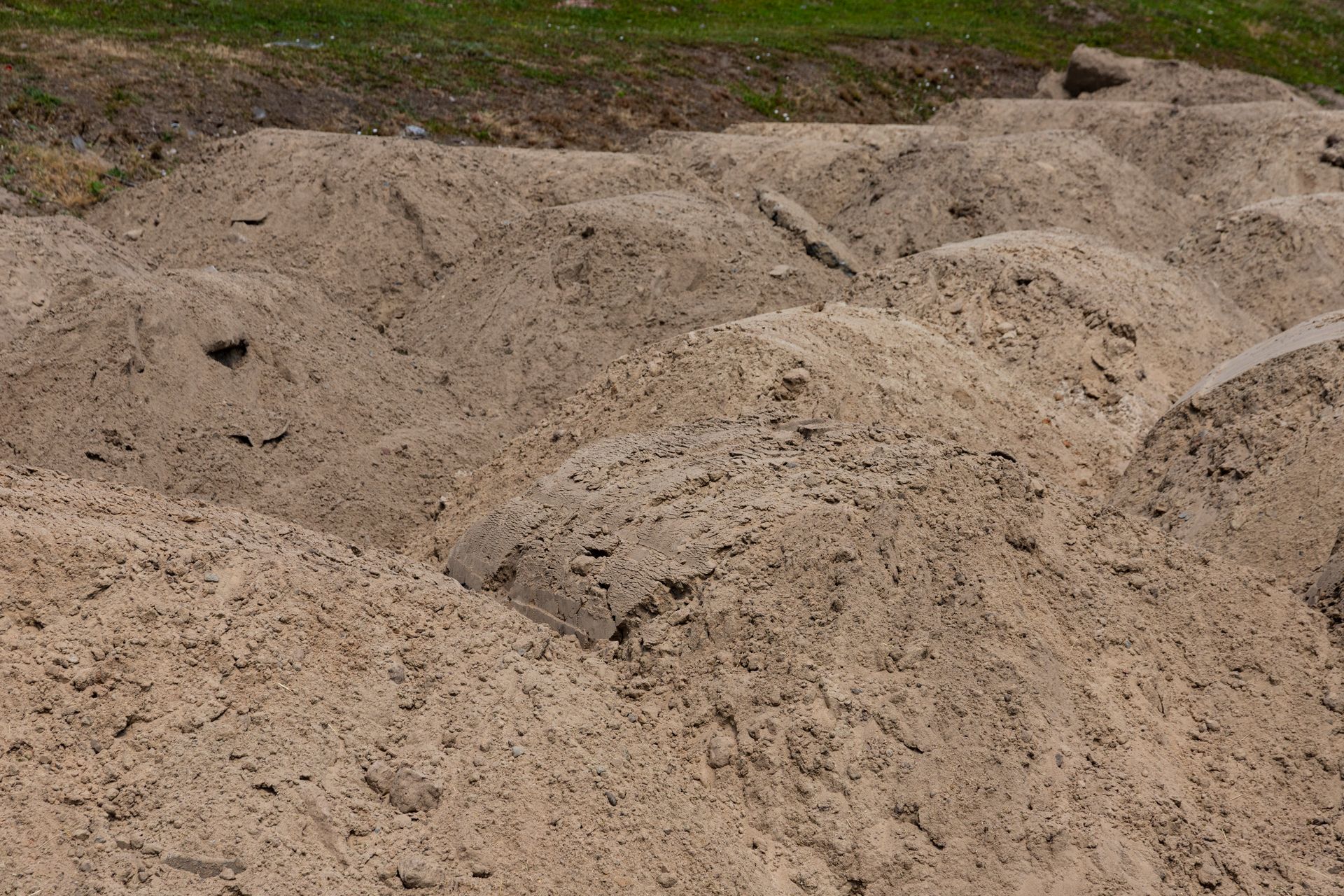 A pile of sand is sitting on the ground in a field.