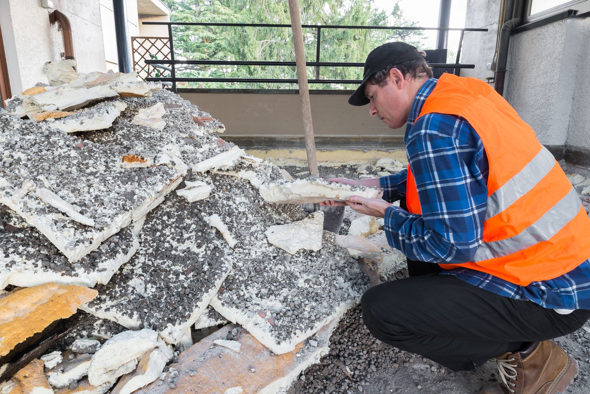 A man is kneeling down in front of a pile of foam.