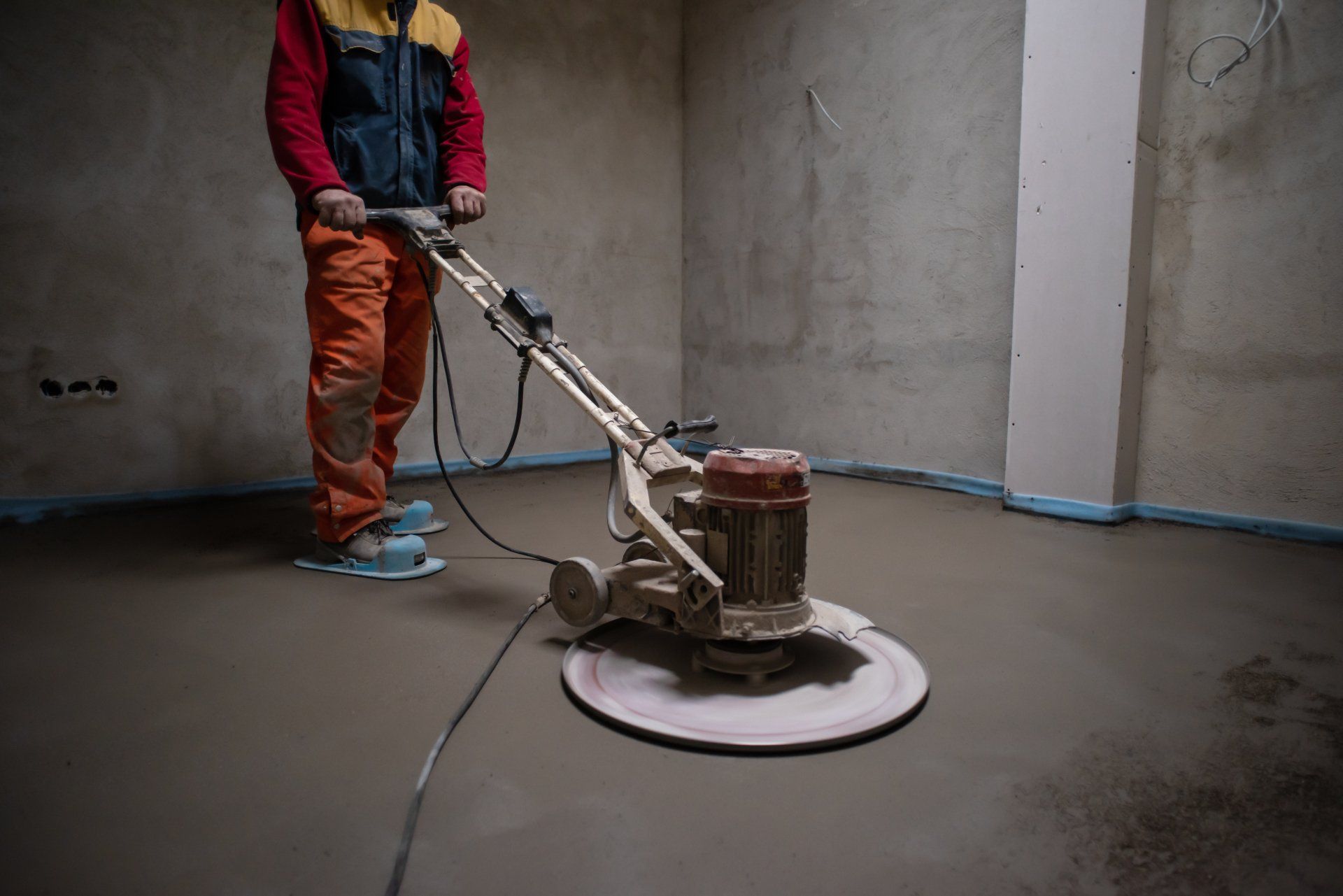 worker flattens the concrete floor