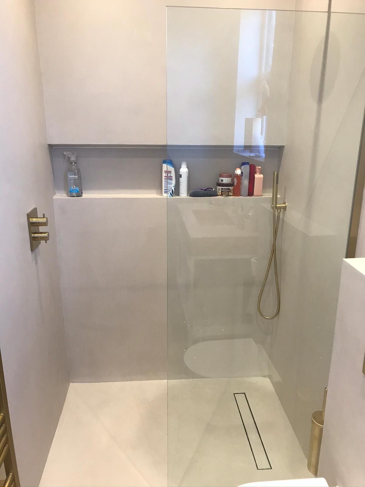 A Microcement Wet Room with a walk in shower , sink and toilet.