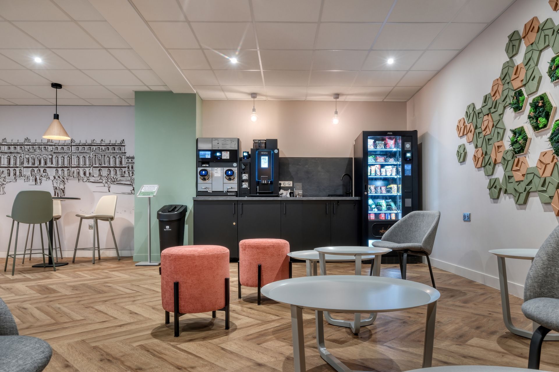 Un salon avec tables, chaises et un distributeur automatique.
