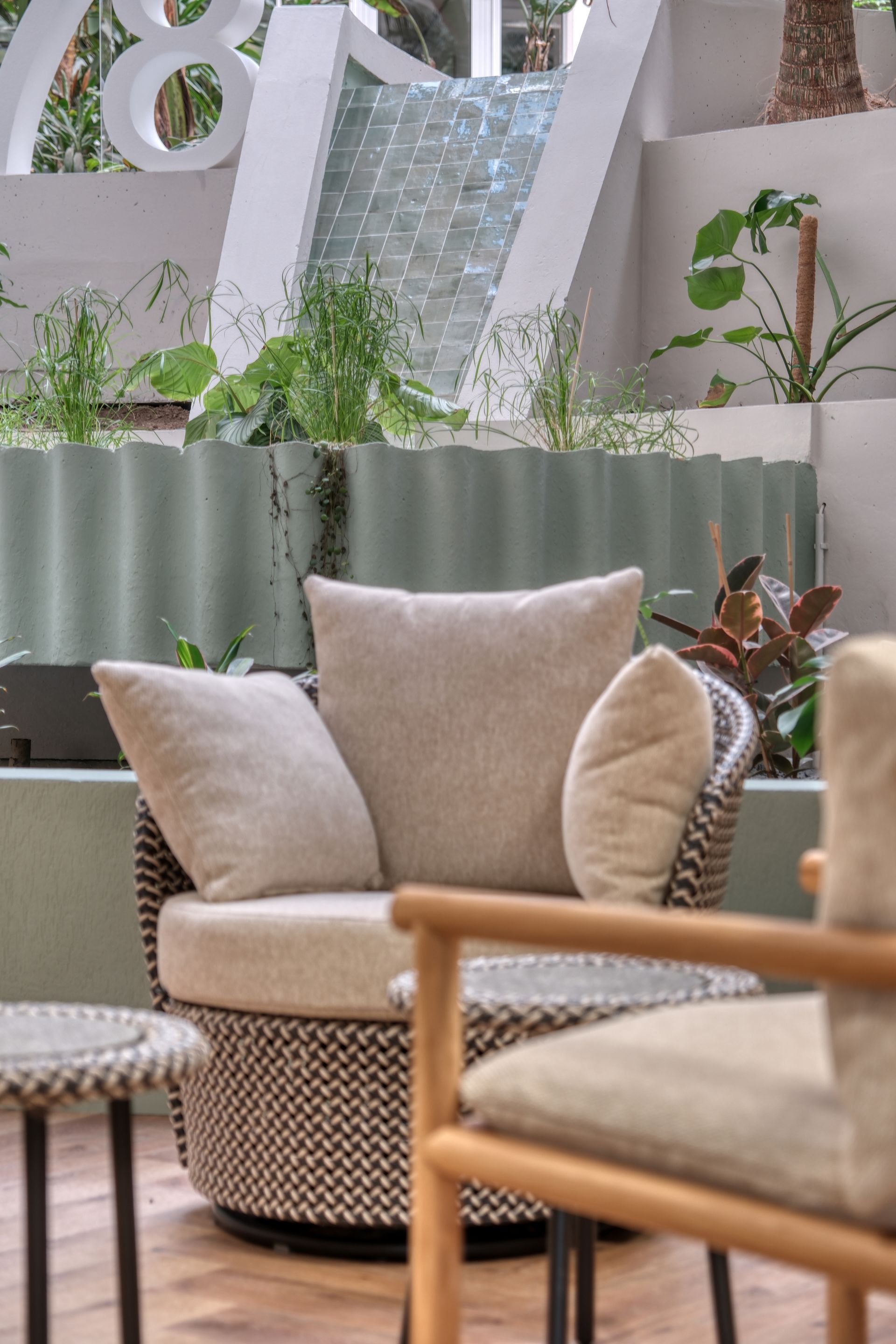 Une chaise avec un oreiller dessus est posée à côté d'une table dans une pièce avec une cascade en arrière-plan.