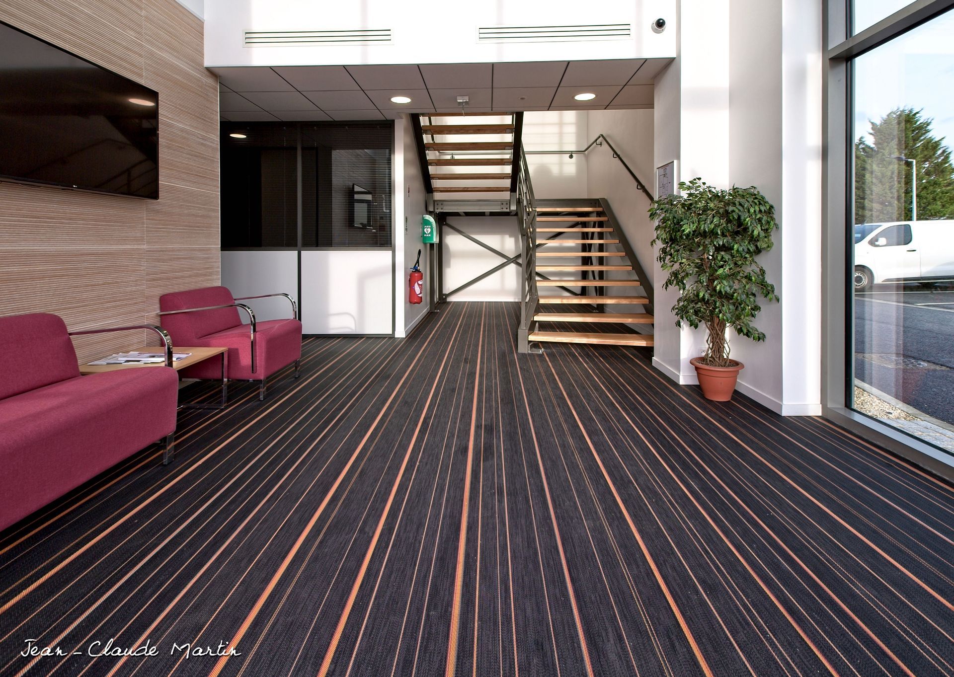 Une salle d'attente avec un escalier et un tapis rayé