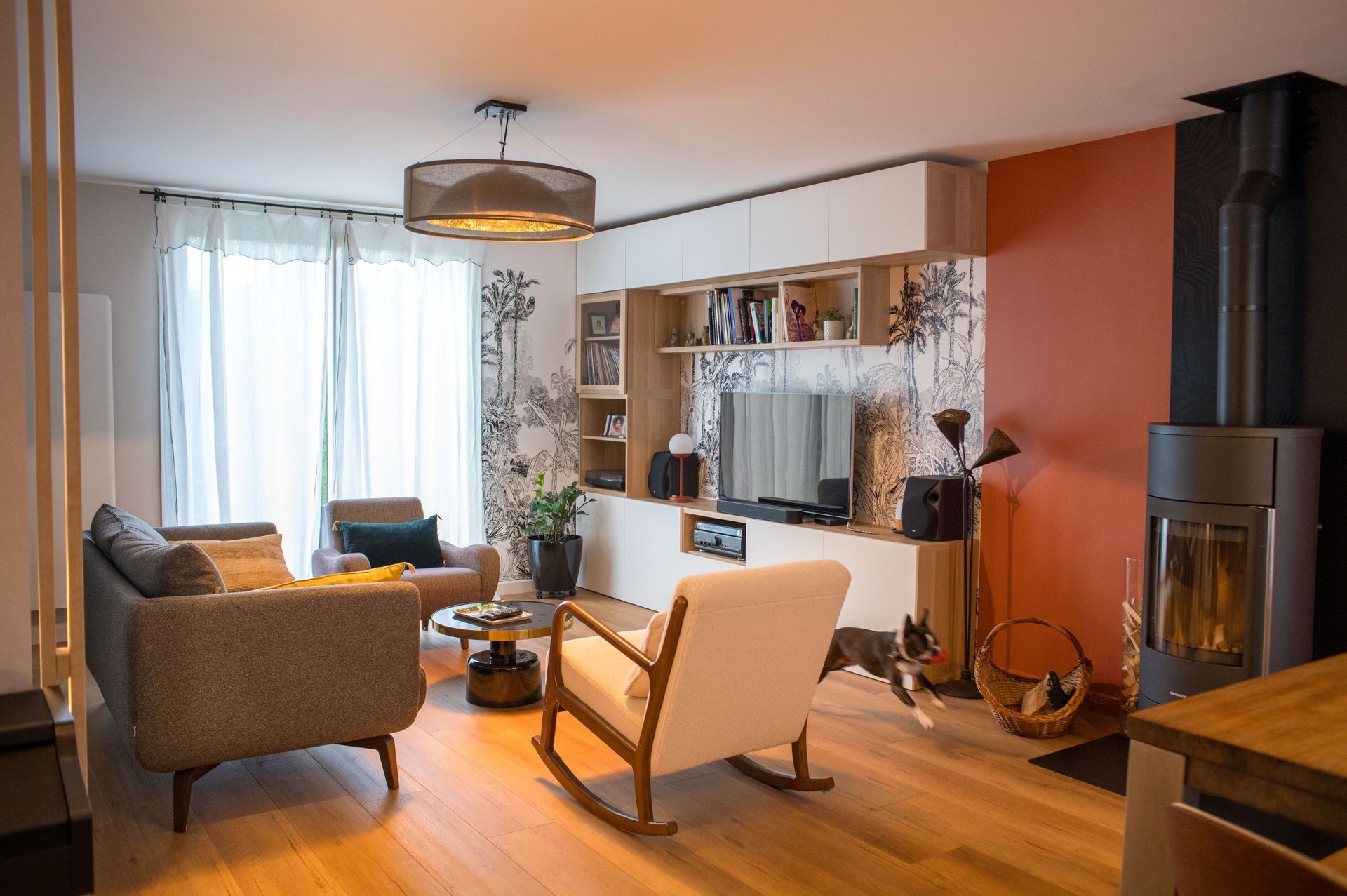 Un salon avec un canapé, une chaise, une table et une télévision.