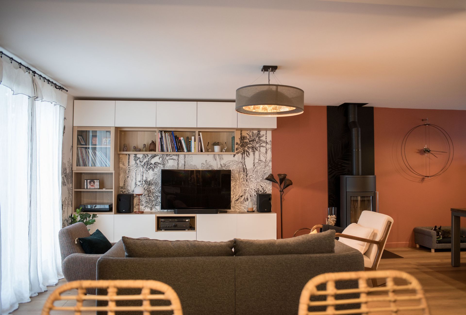 Un salon avec un canapé, des chaises, une télévision et une cheminée.