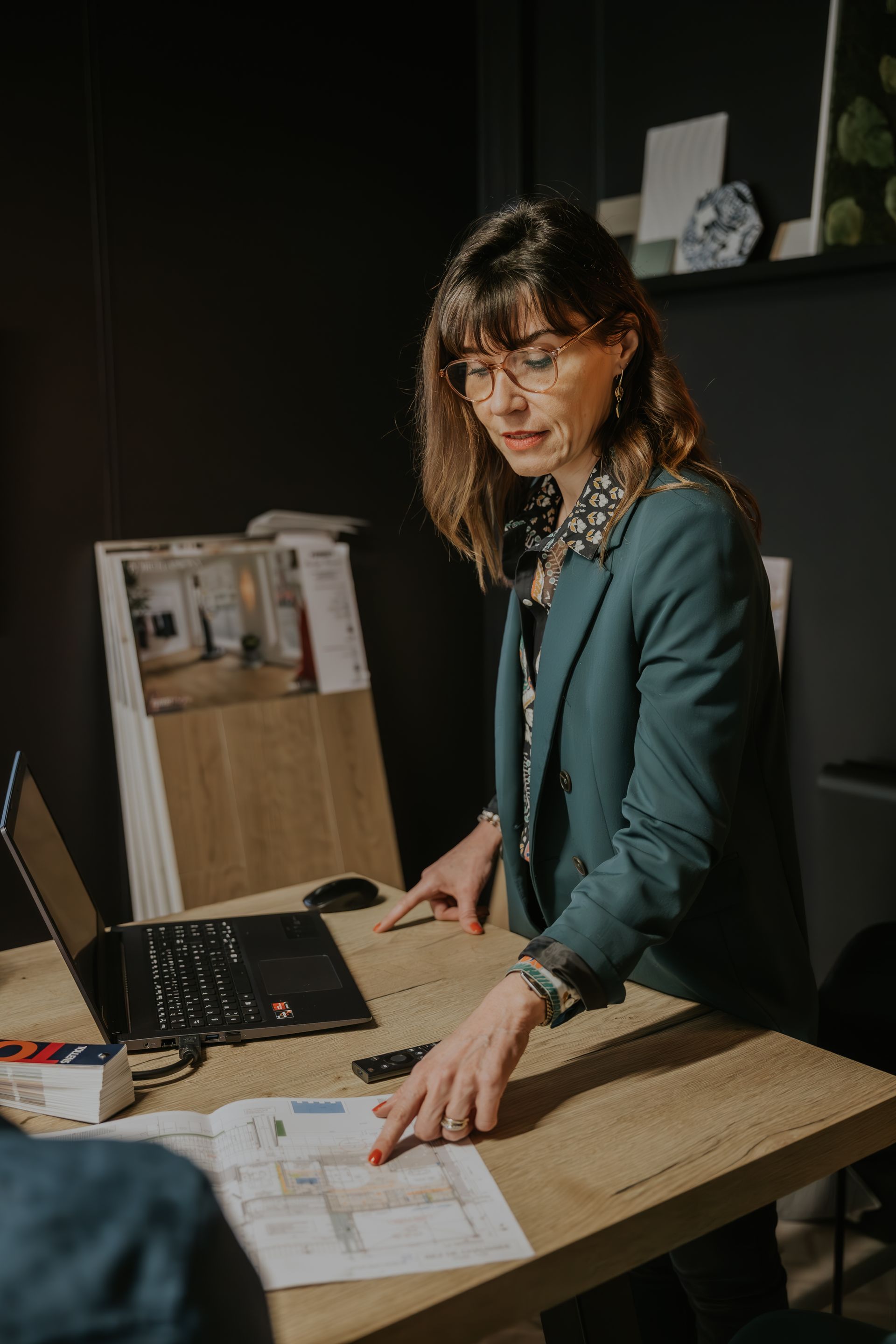 Une femme est assise à un bureau devant un ordinateur portable.