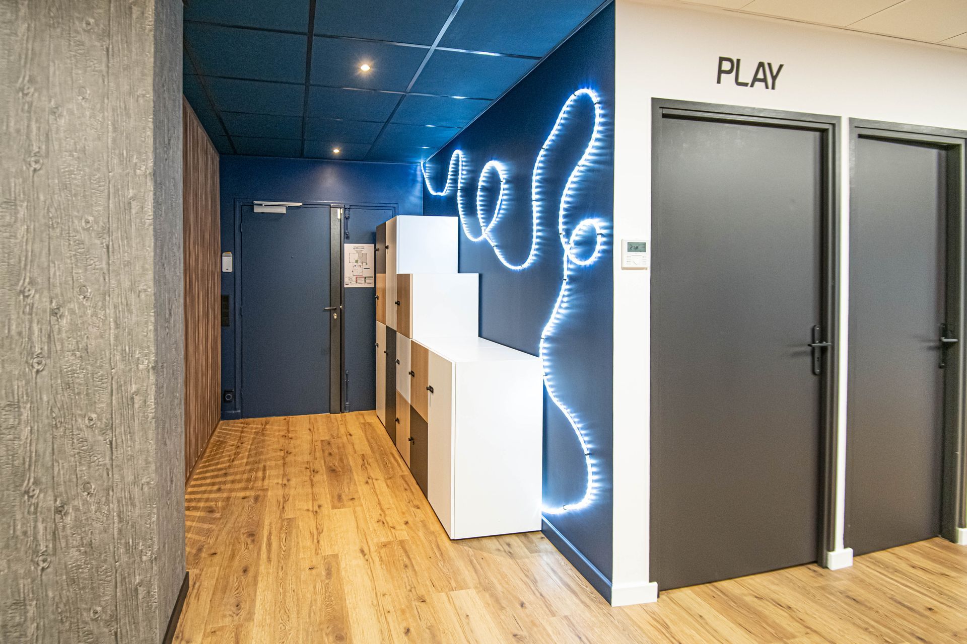 Un couloir avec un panneau sur le mur qui dit « jouer ».