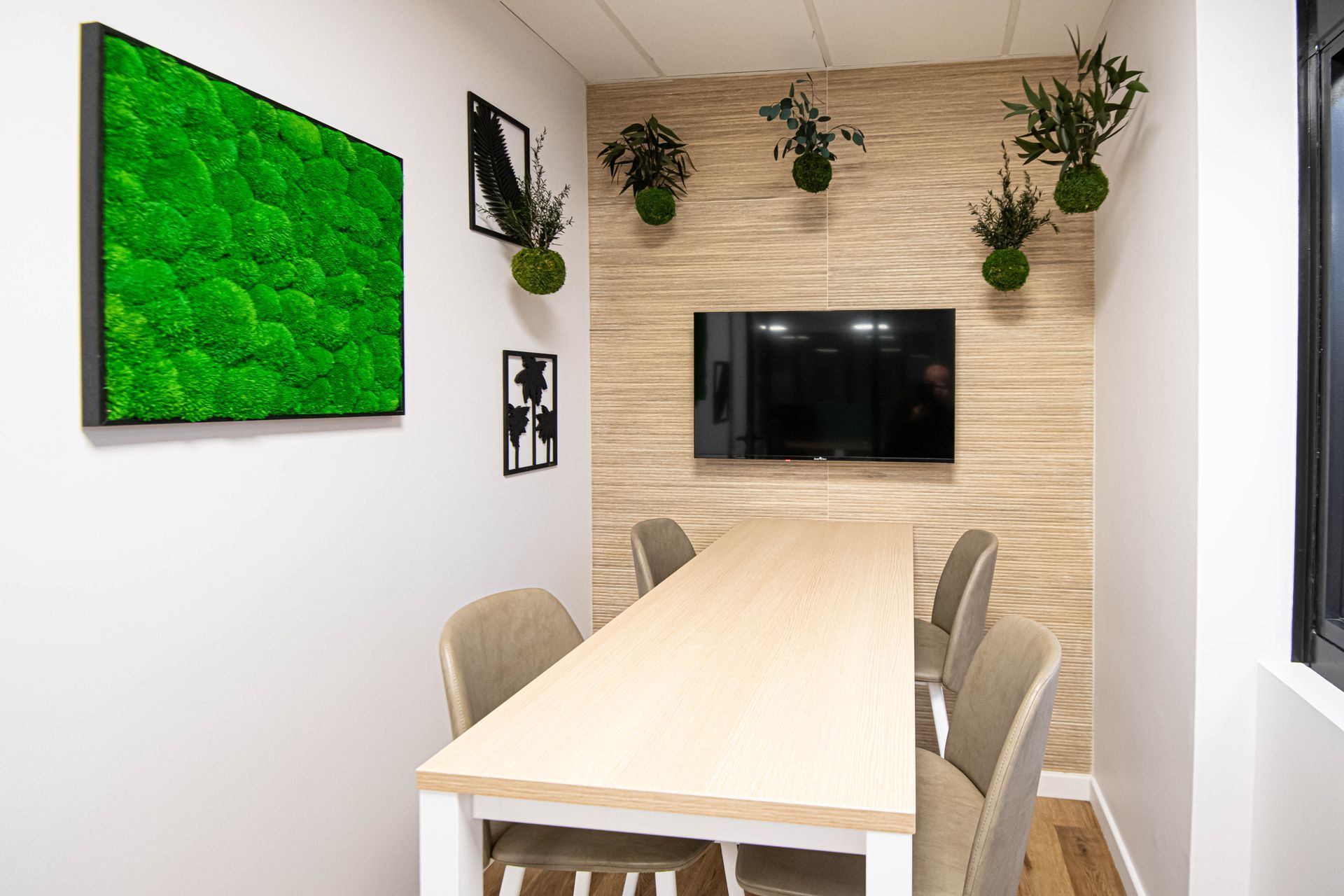 Une salle de conférence avec une longue table et des chaises et une télévision à écran plat.