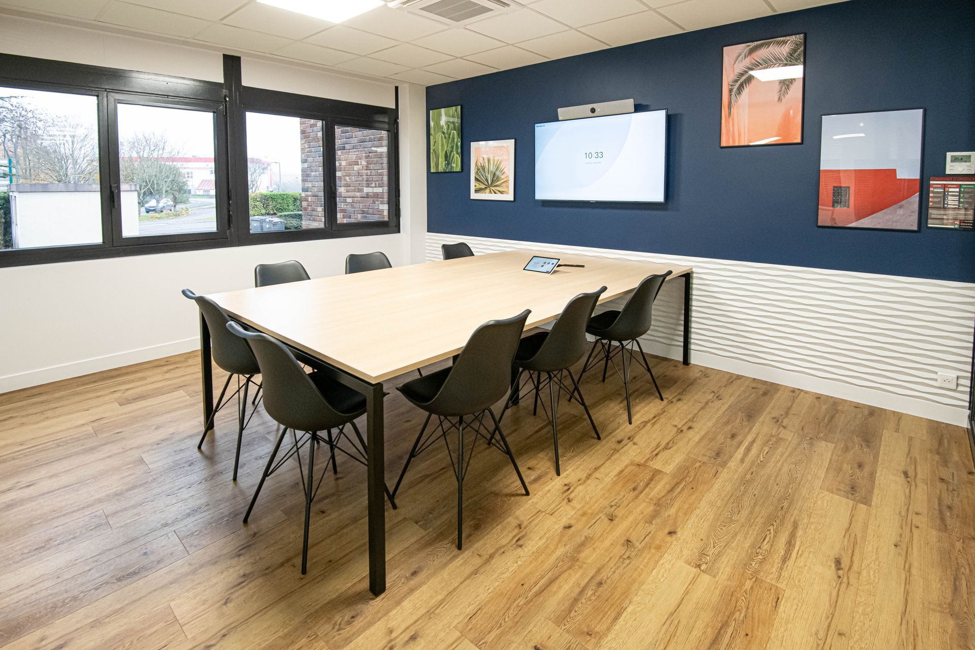 Une salle de conférence avec une longue table et des chaises.