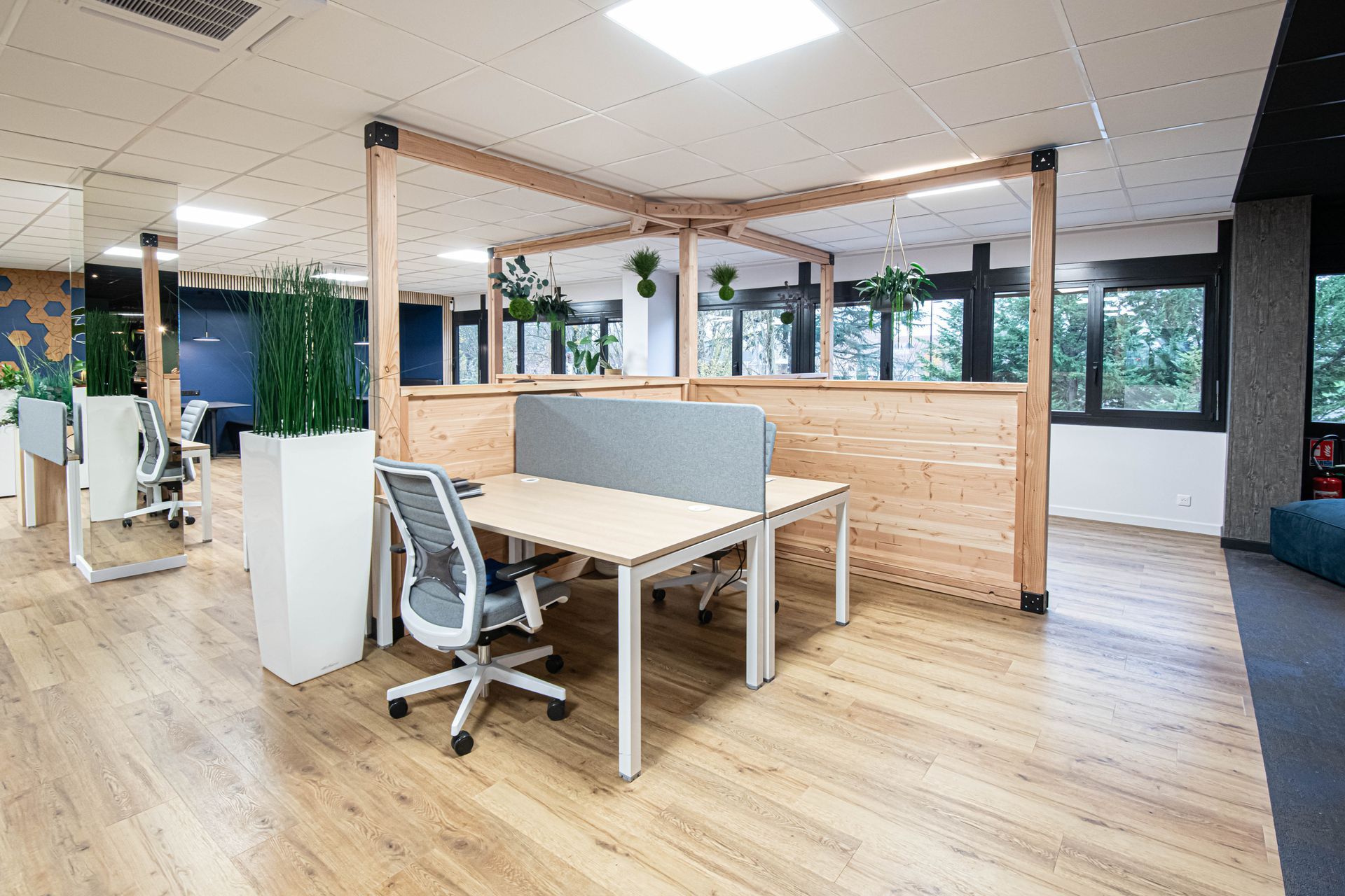 Un grand bureau avec parquet, tables et chaises.