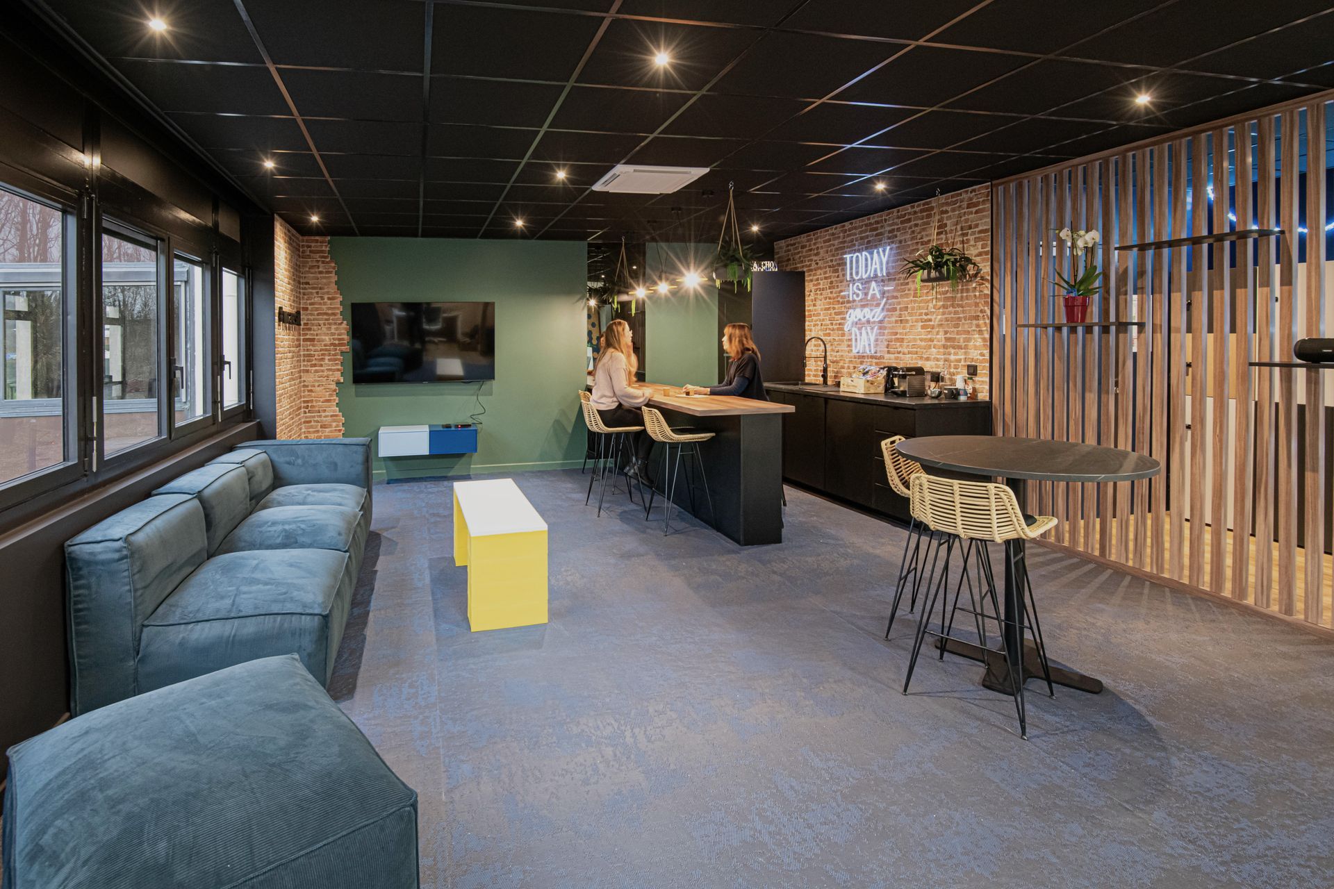 Un salon avec un canapé, une table, des chaises et une télévision.
