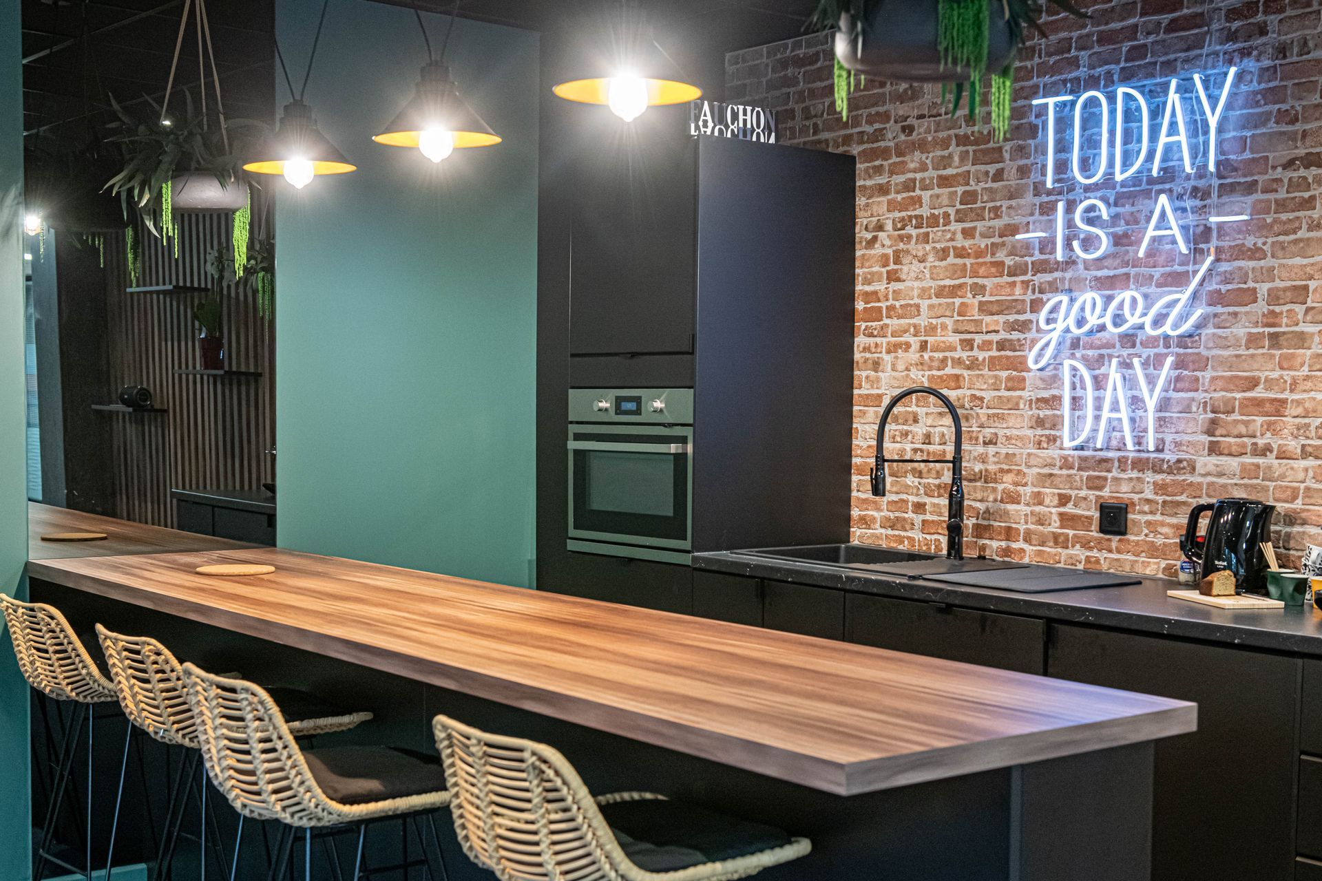 Une cuisine avec une longue table et des chaises en bois et une enseigne au néon indiquant « aujourd'hui est un bon jour ».
