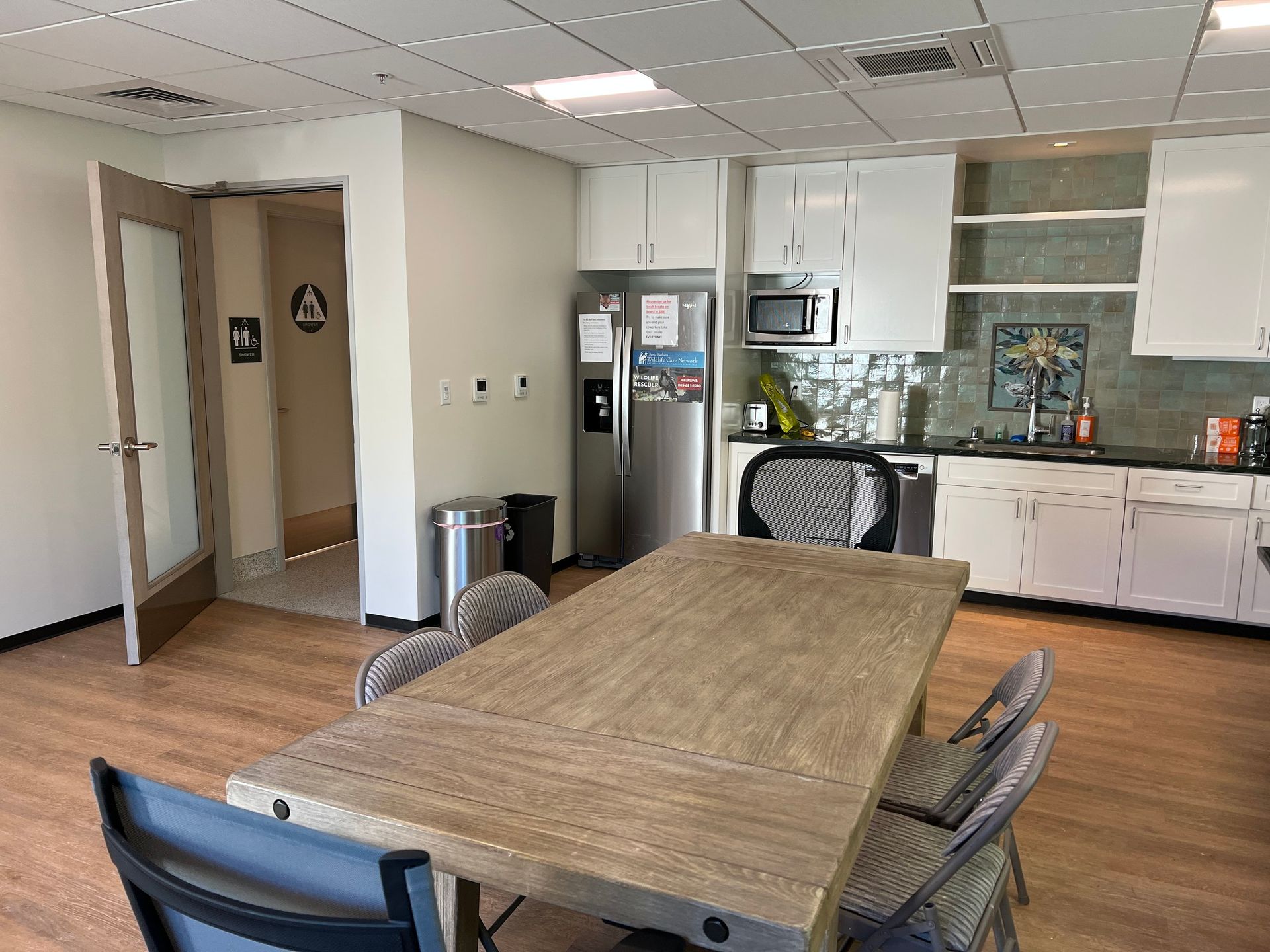 A kitchen with a table and chairs and a refrigerator.