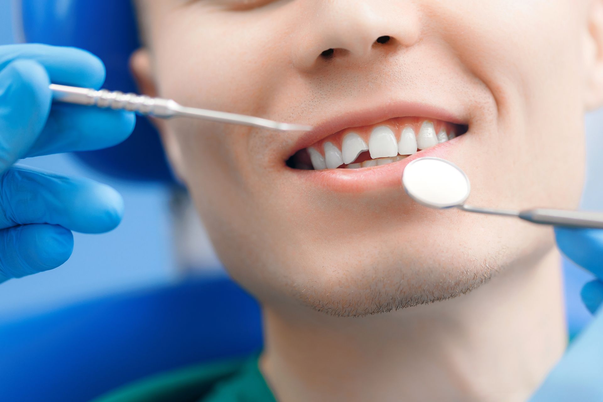 Close-up of a smiling mouth with a finger pulling down the lower lip to show the teeth
