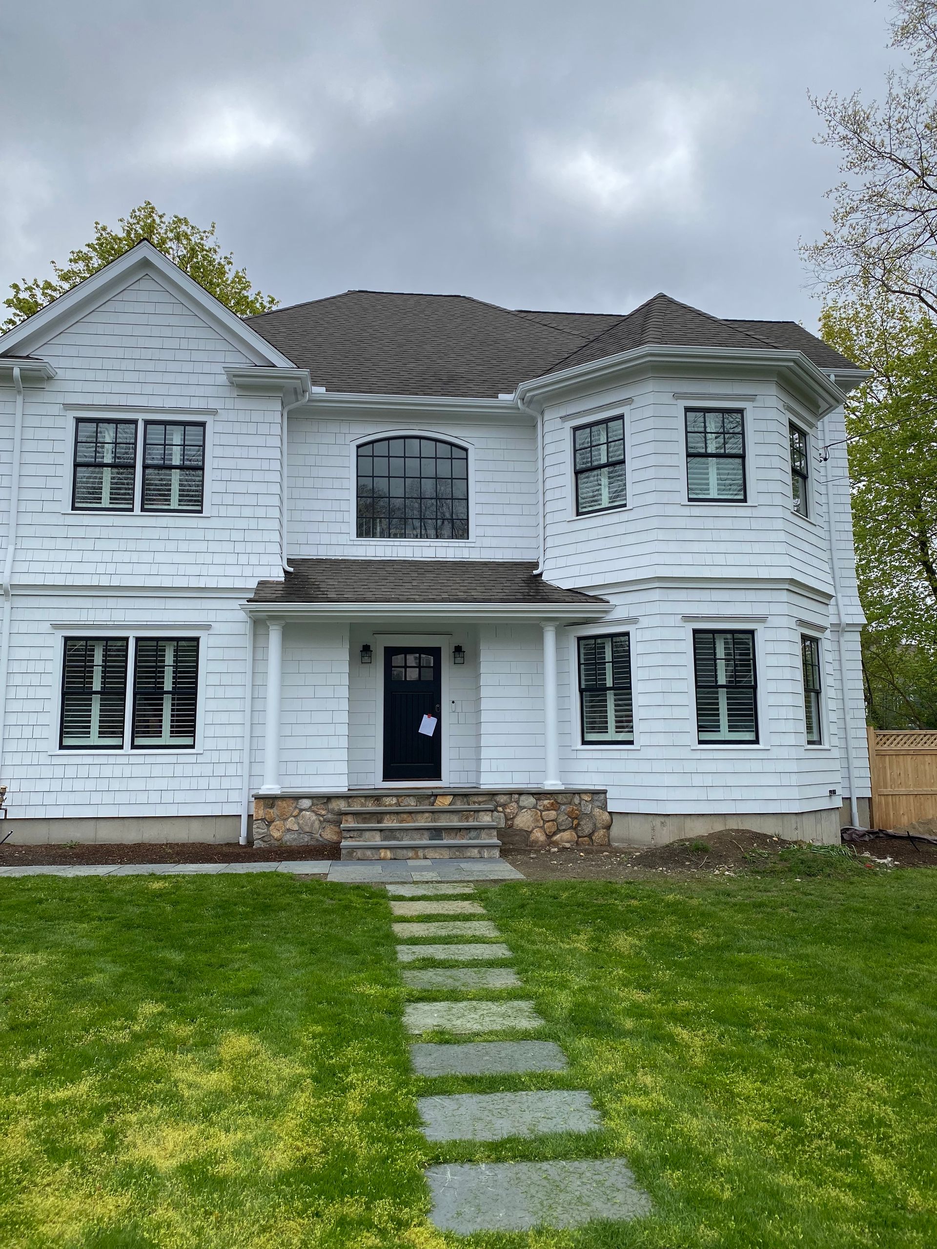 A large white house with a walkway leading to the front door.