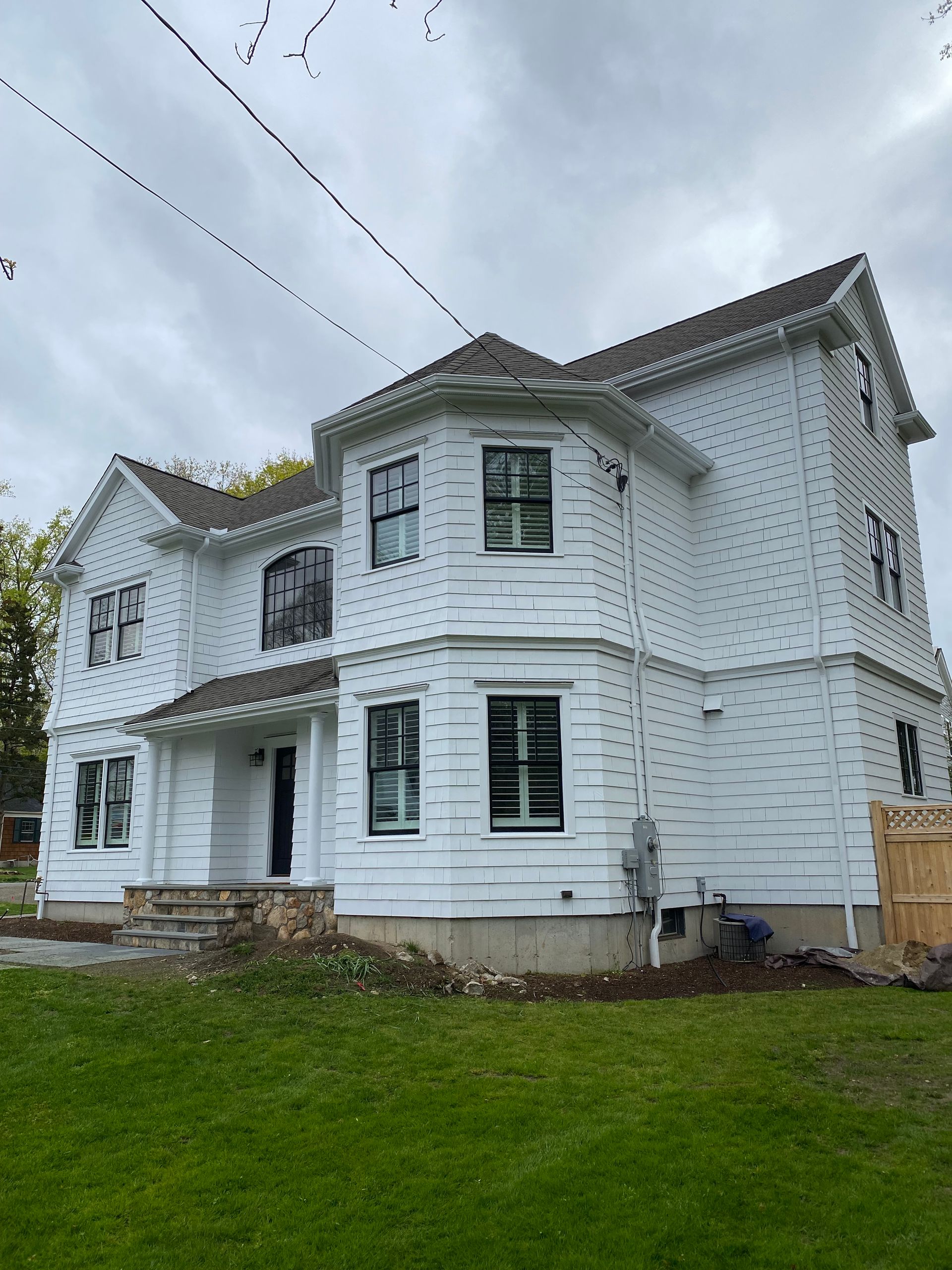 A large white house with a curved roof is sitting on top of a lush green lawn.