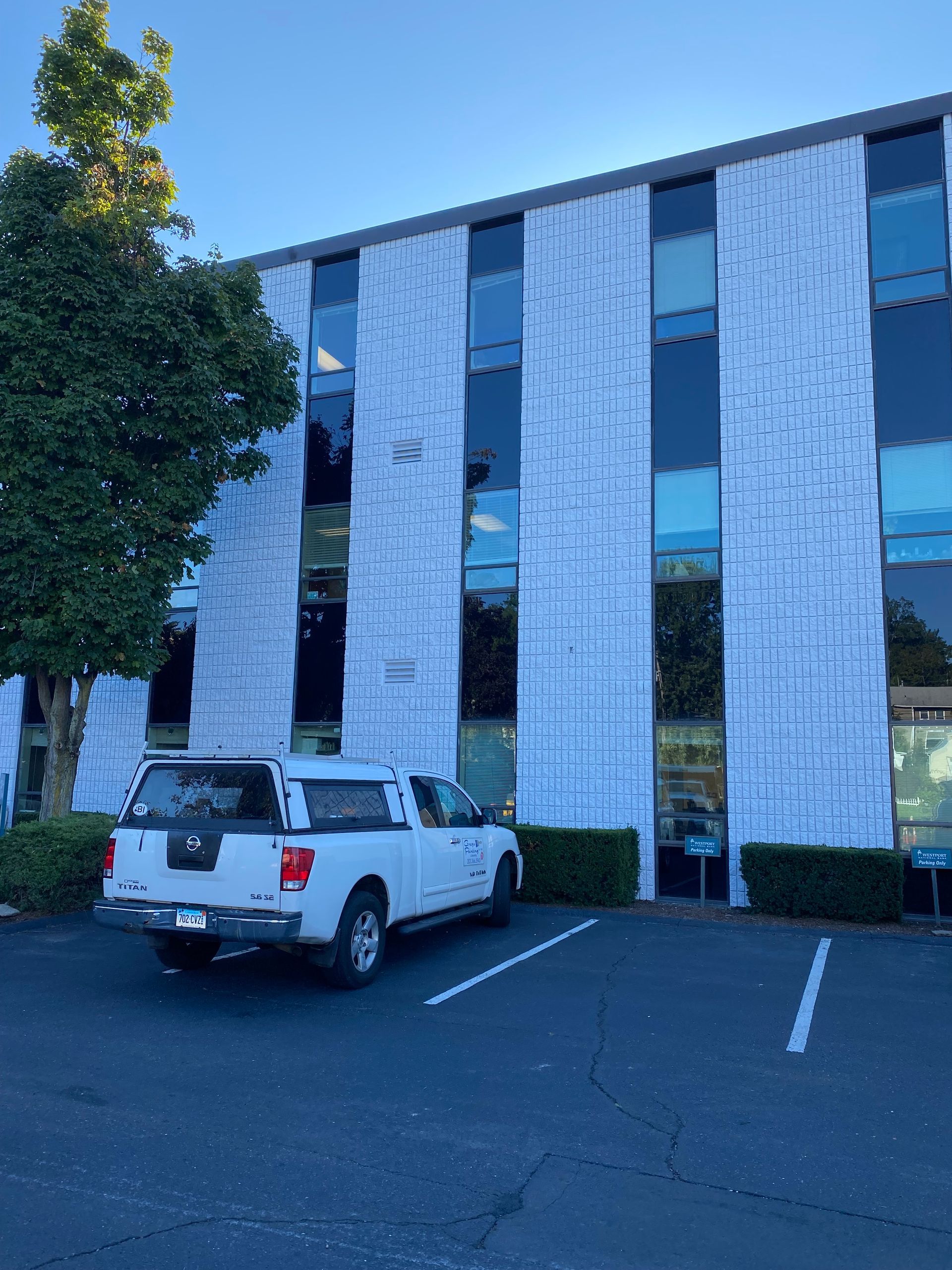 A white truck is parked in front of a building.