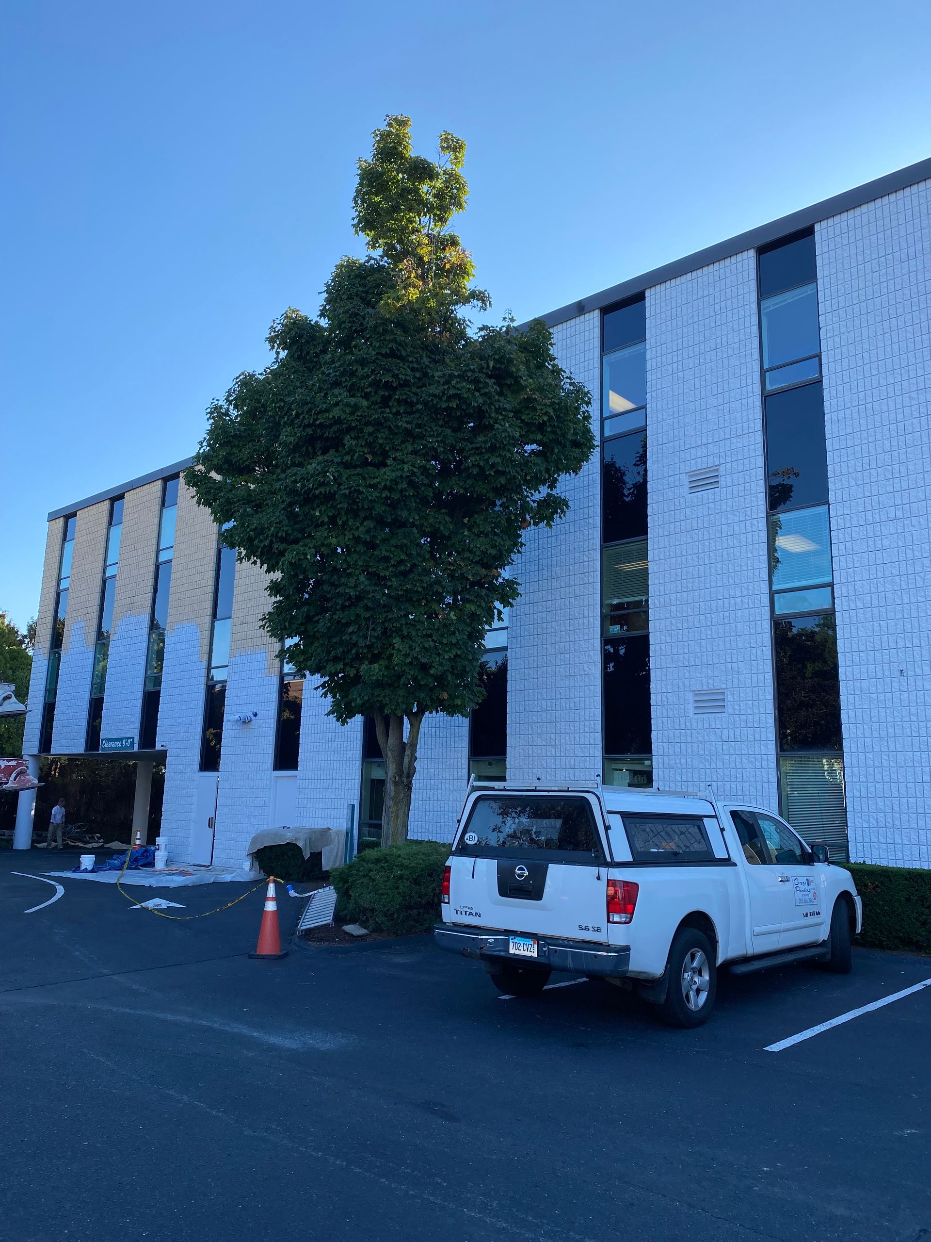 A white truck is parked in front of a building