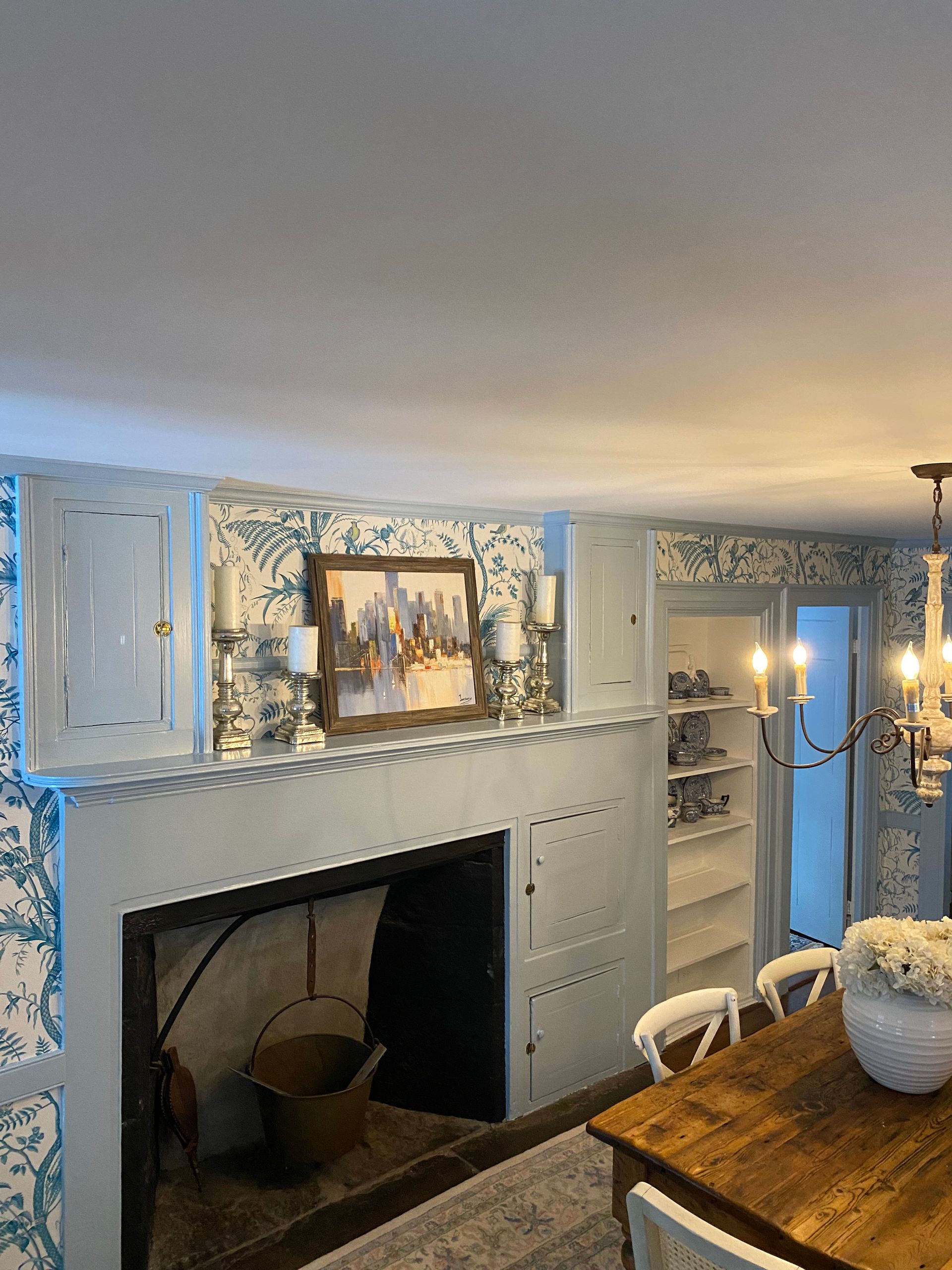 A dining room with a fireplace , table and chairs.