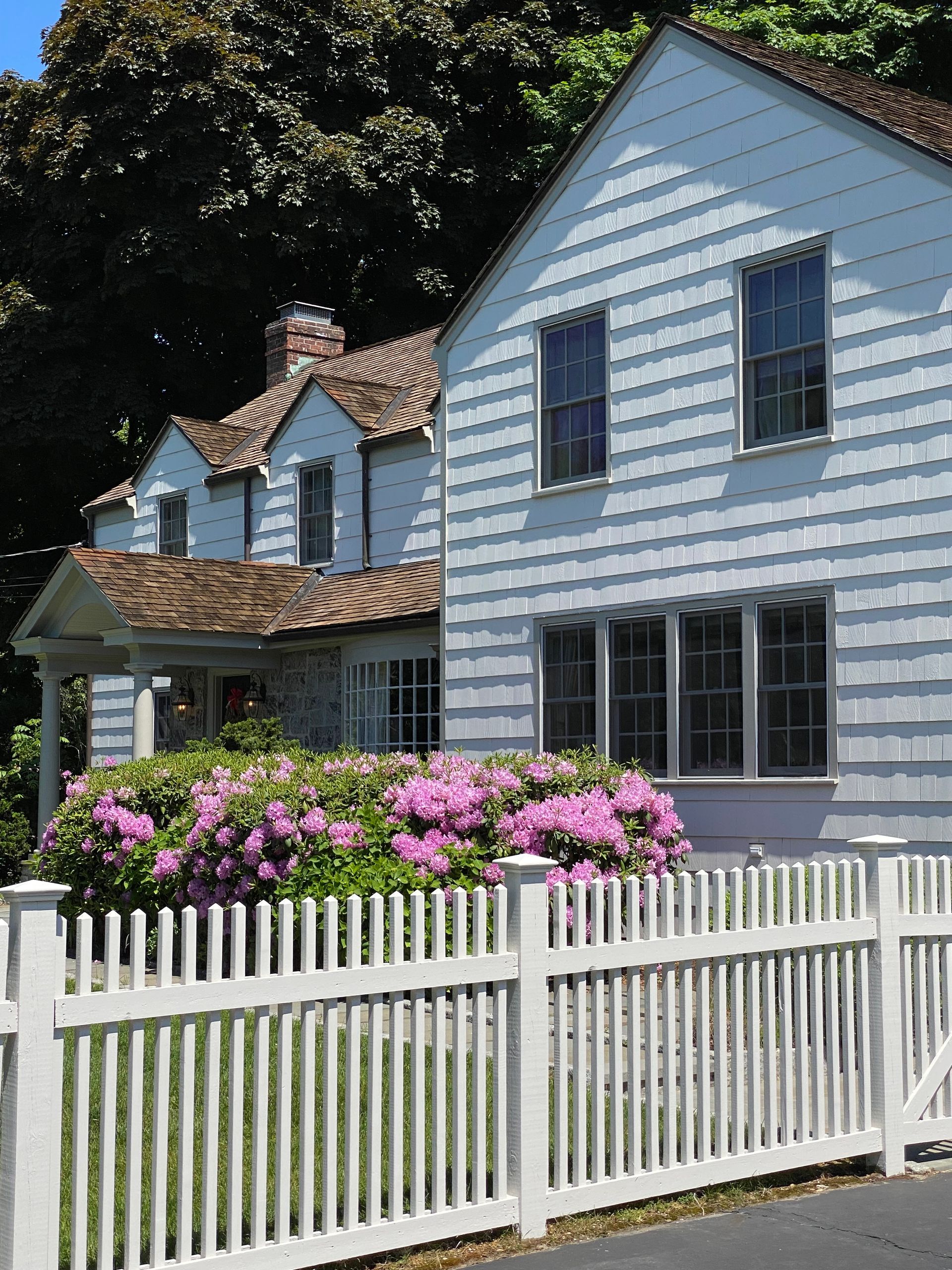 A white house with a white picket fence in front of it