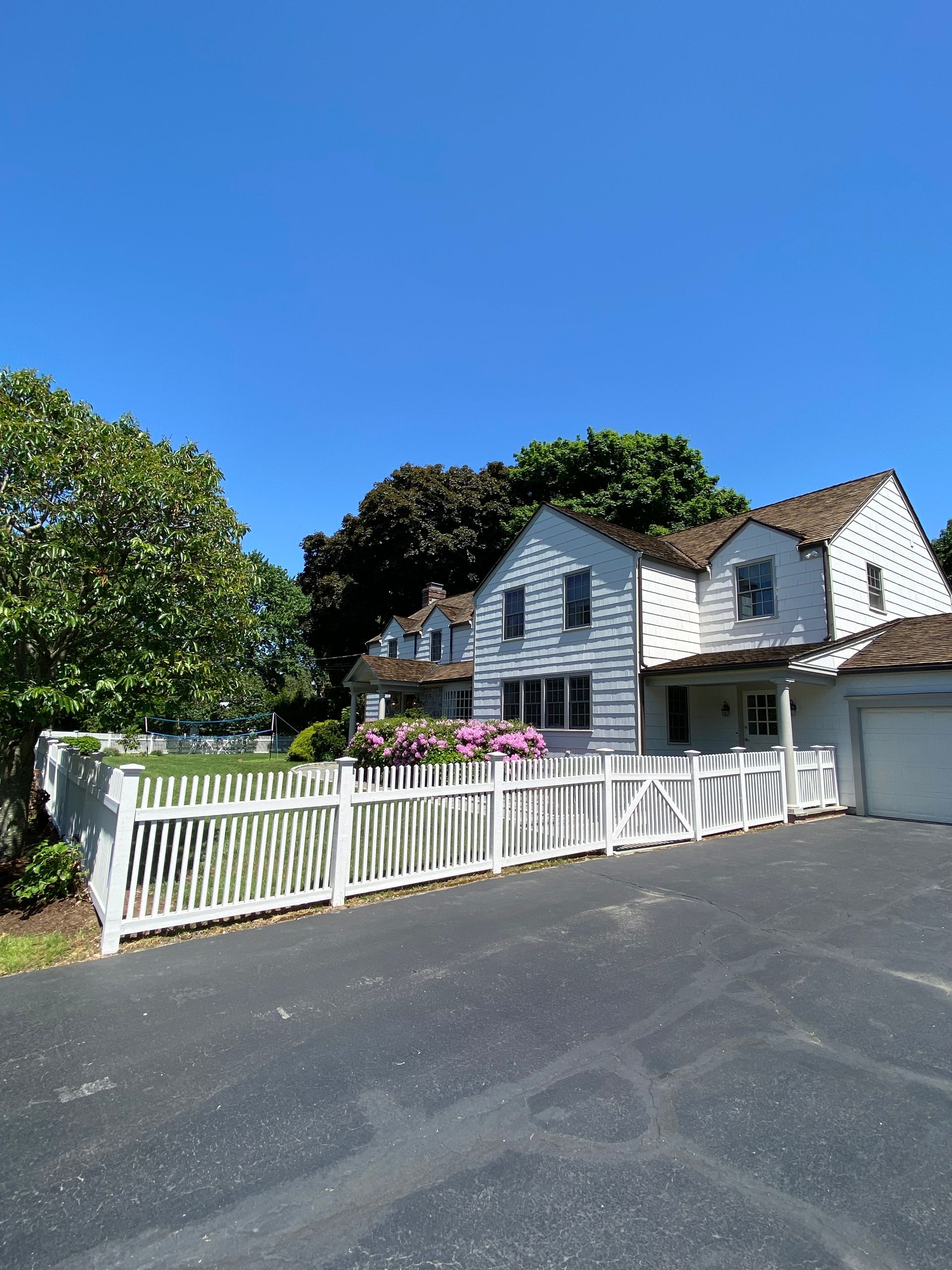 A large white house with a white picket fence in front of it