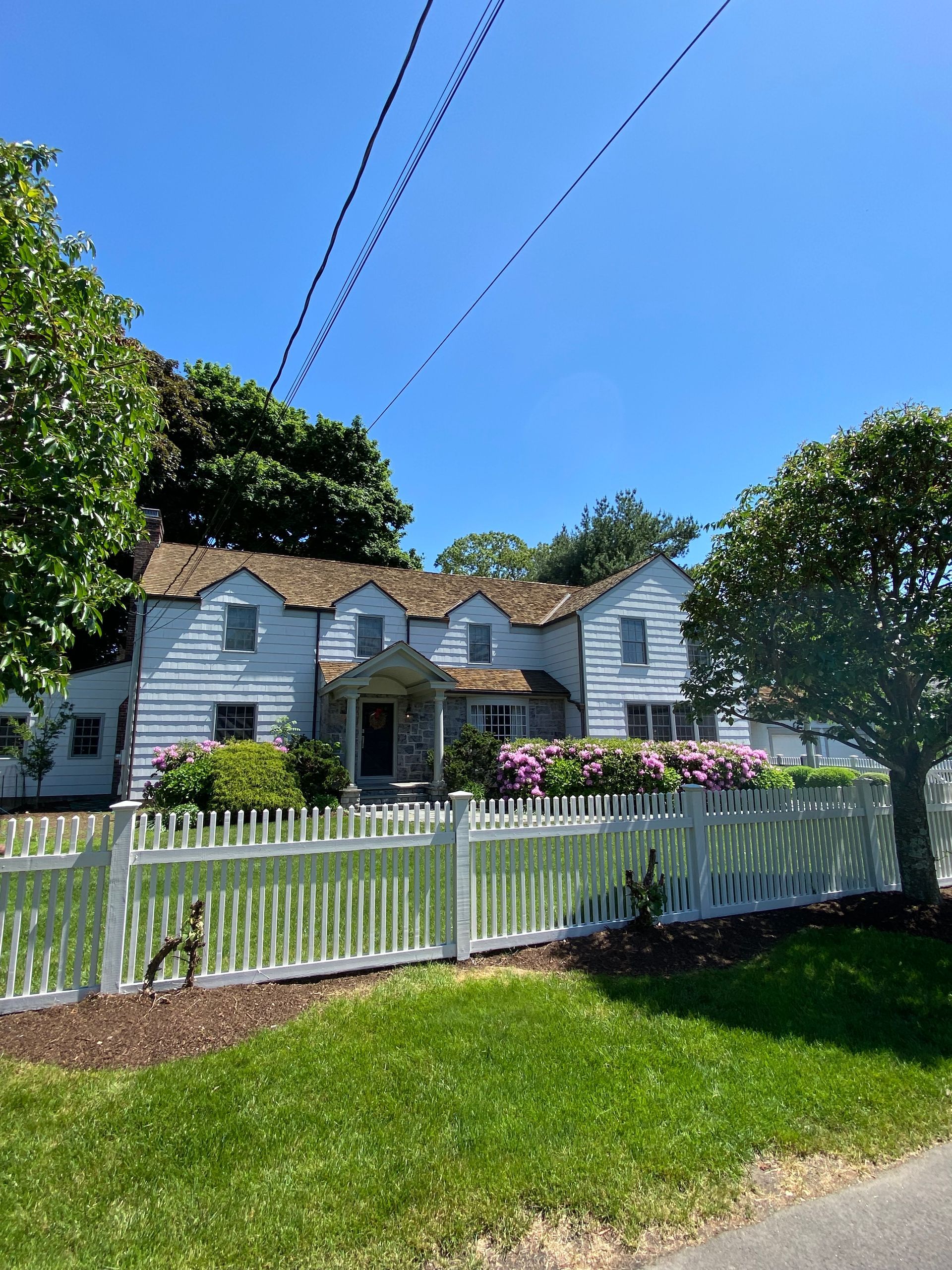 A white house with a white picket fence in front of it