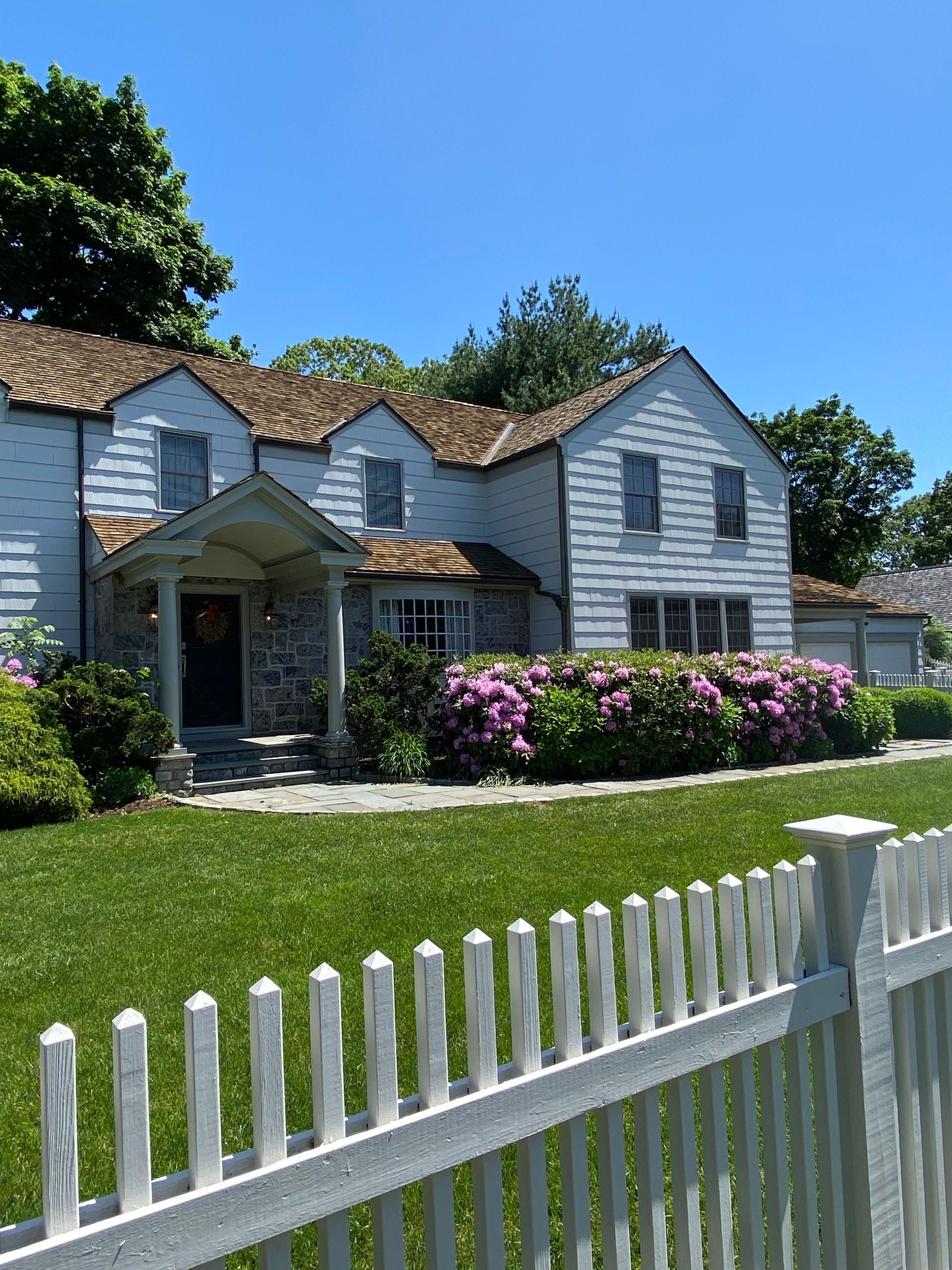 A large white house with a white picket fence in front of it