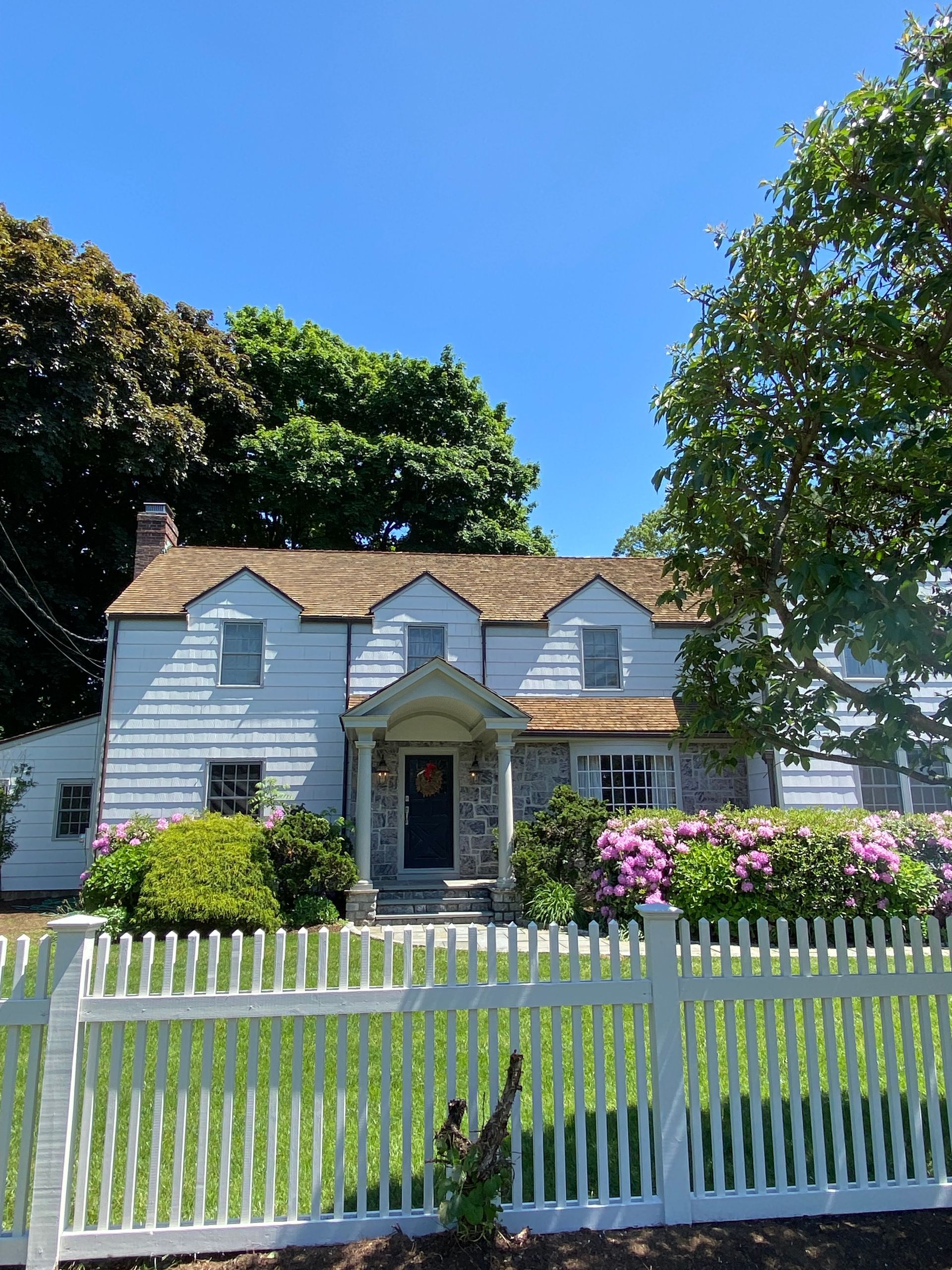 A white house with a white picket fence in front of it
