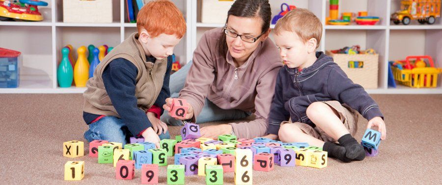 teacher showing numbers to 2 kids