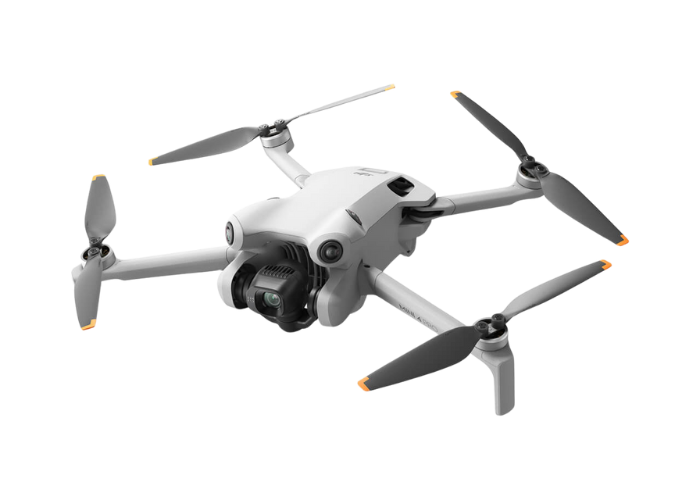 A white DJI  Mini 4 Pro drone with a camera attached to it is flying on a white background.