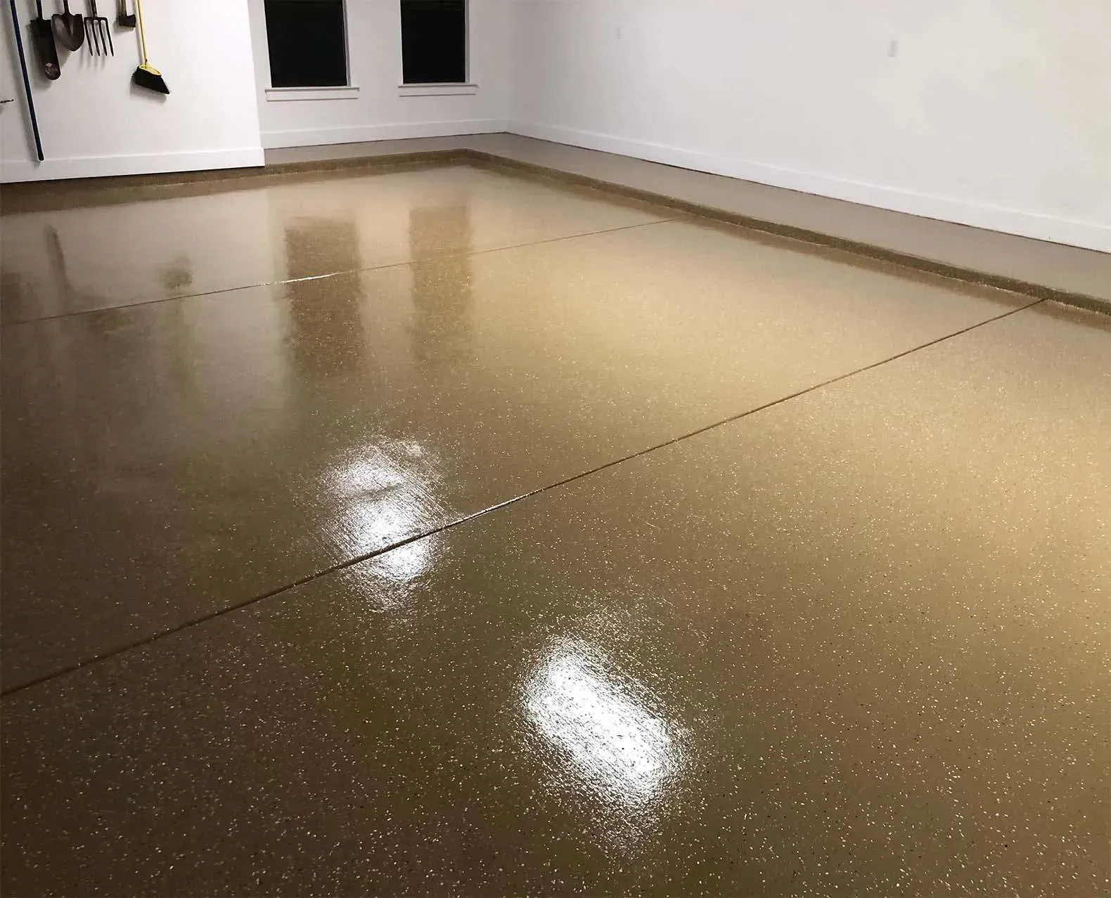 A person is painting a wall with a brush and two cans of paint.