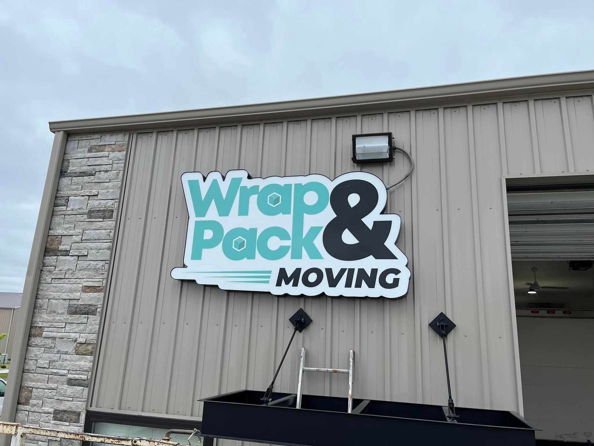A sign on the side of a building that says wrap and pack moving.