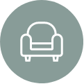 White line drawing of an armchair on a sage green background.