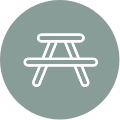 Picnic table icon in a grey circle.