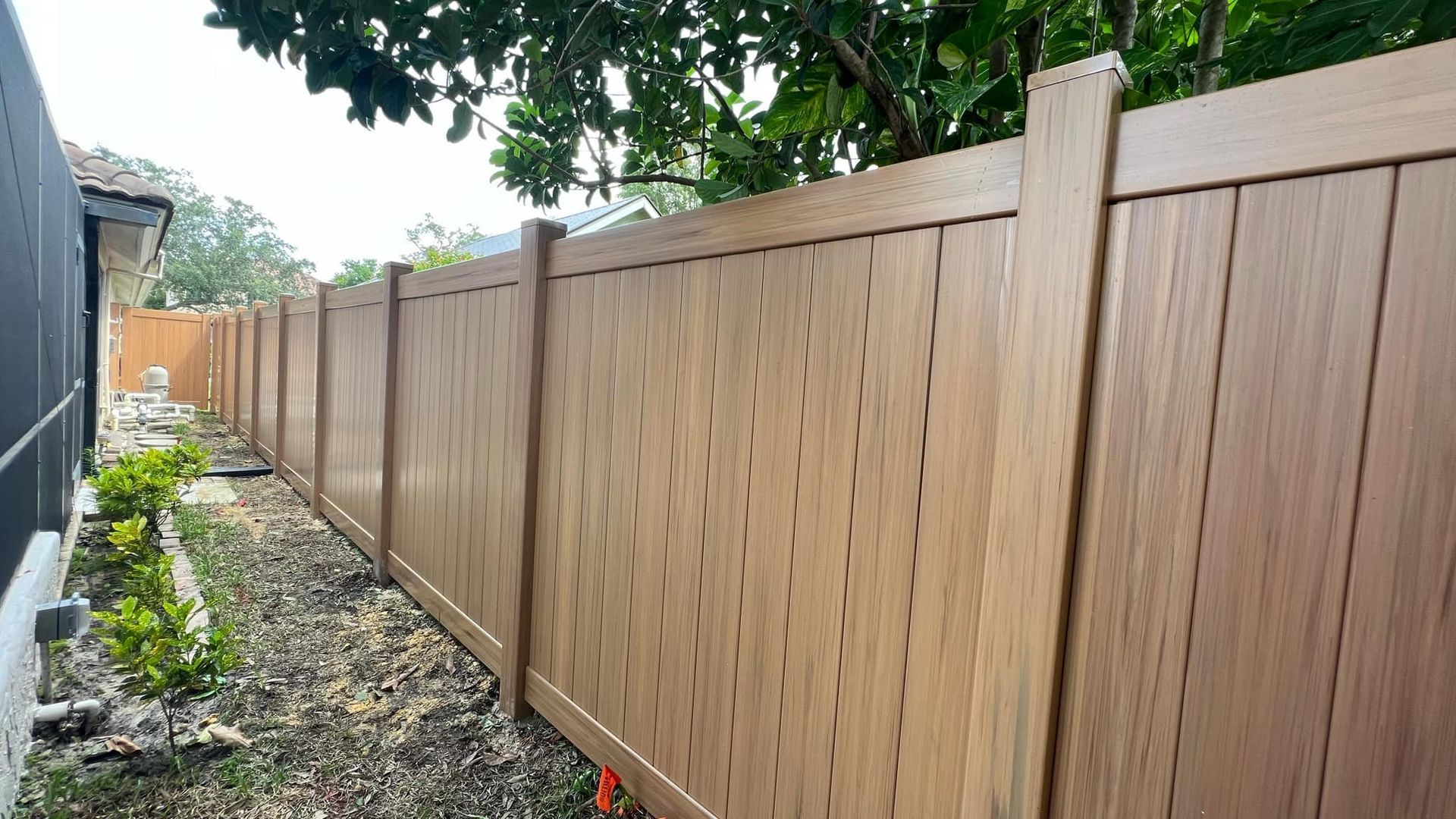 Wooden privacy fence in a yard, brown color.